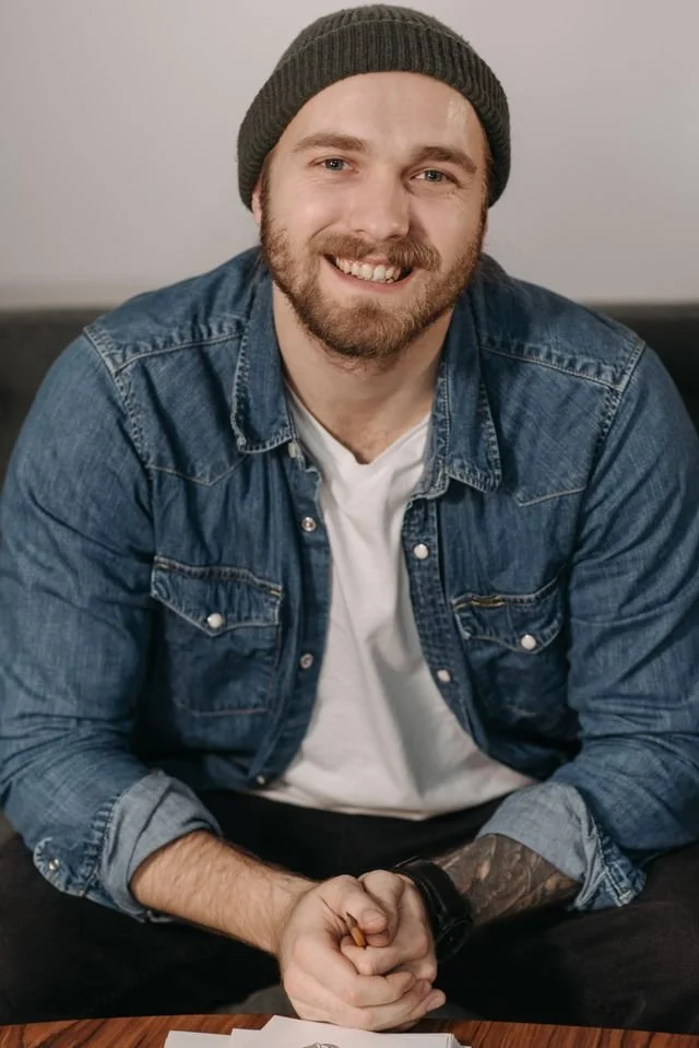 a smiling man in a green beanie