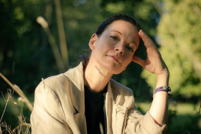 A woman with a hand on her head thinking