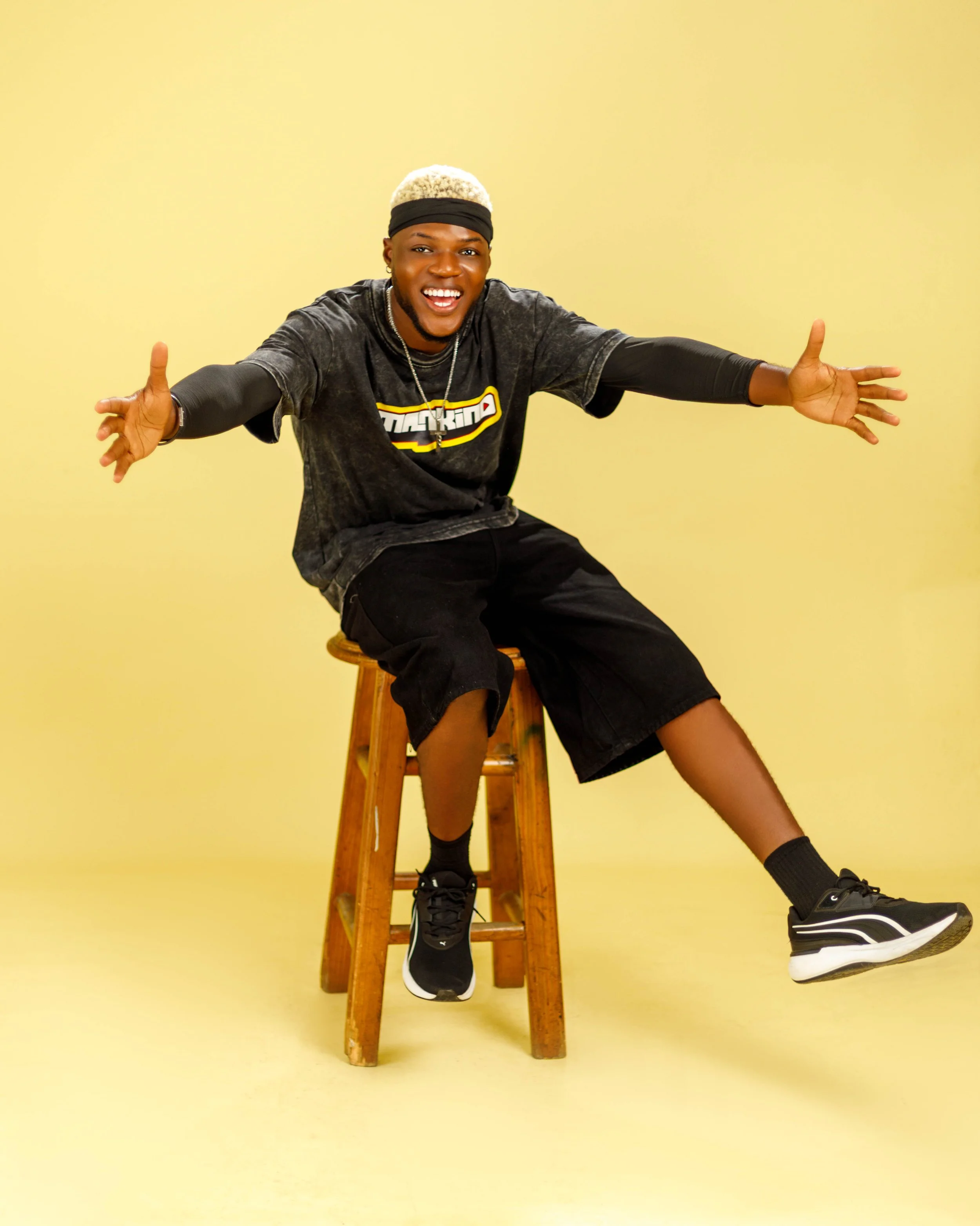 Spyrex sitting on a stool in a MANKIND shirt against a yellow background