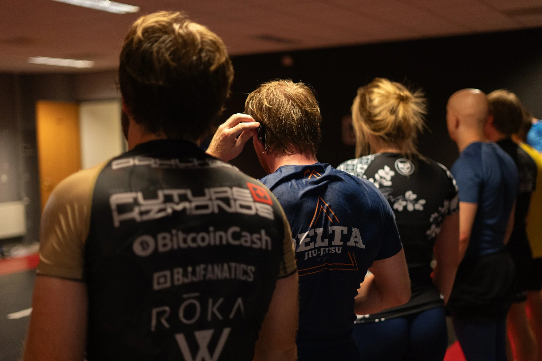 Mensen die zich voorbereiden voor een sportschool of sportevenement, met enkele sportoutfits en fitnessmerken zichtbaar.