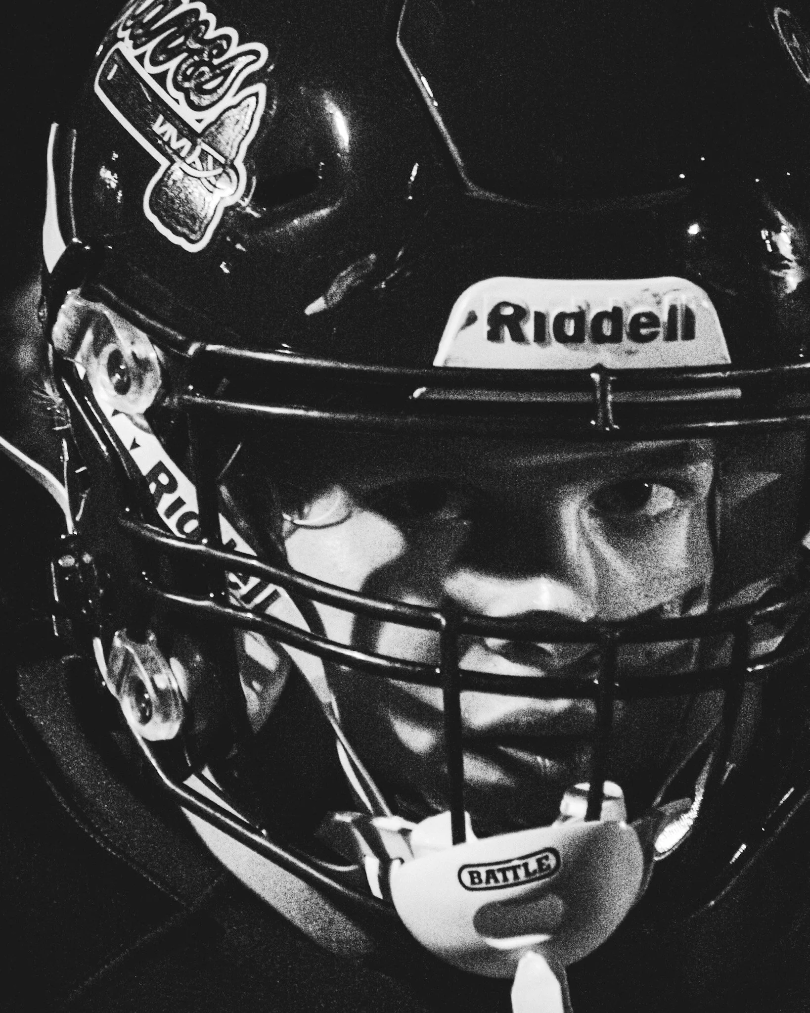 Close-up of a toy or model spaceship with stickers labeled 'Riddell' and 'Battle,' in black and white.
