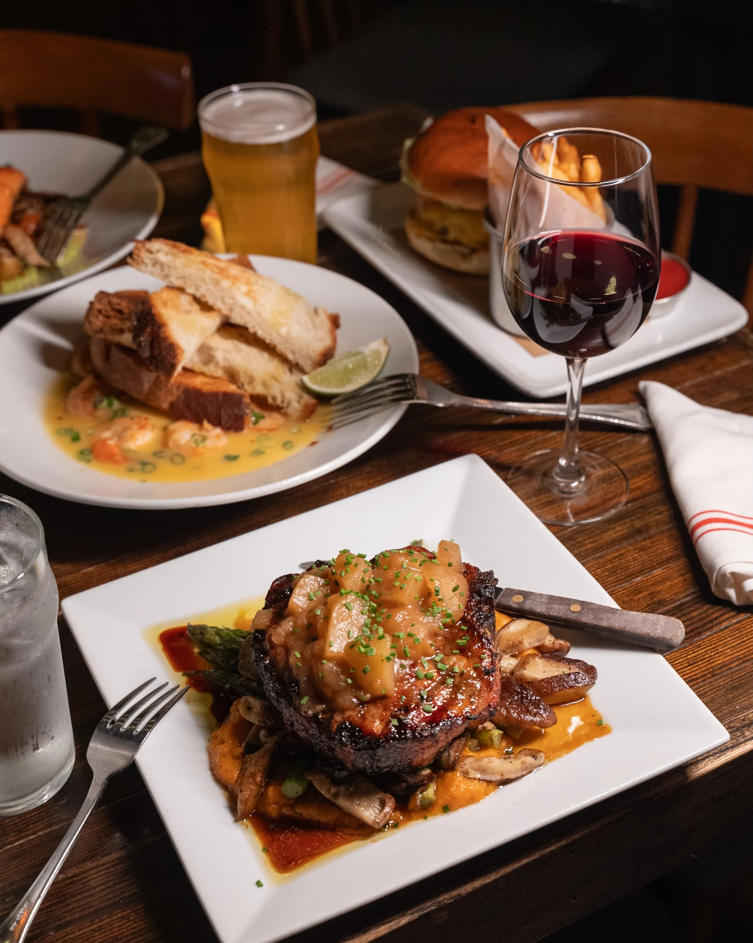 Friday energy looks like this. Pork Chop, Garlic Shrimp, a glass of red, and nowhere to be. We&rsquo;re on Ditmars. Come through.