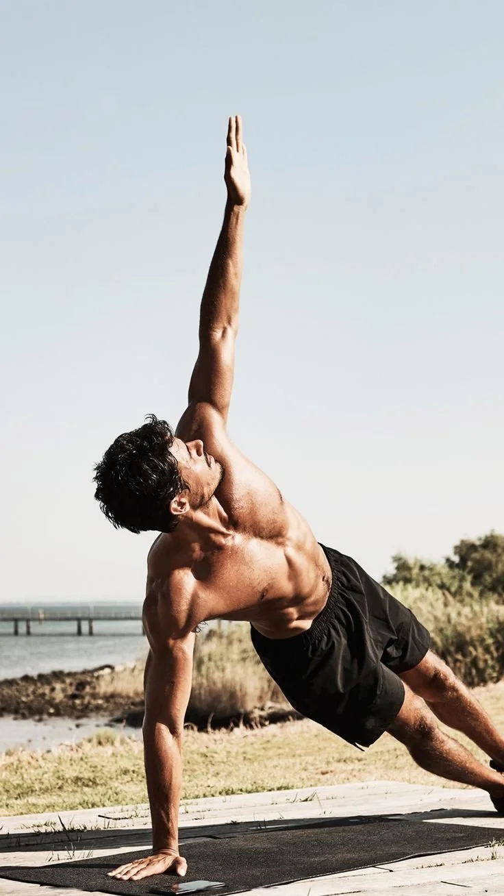 Mann macht Yoga-Posen am Strand bei Sonnenaufgang