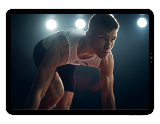 Male athlete in athletic wear on a smartphone screen, preparing to sprint with bright lights in the background.
