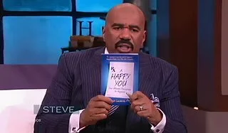Man in a suit holding a birthday card that says 'Happy You' on it.