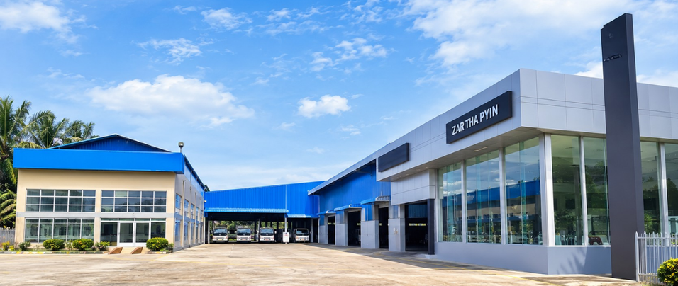 Exterior of a modern car dealership with multiple cars inside and a sign that reads 'ZAR THA PYIN'