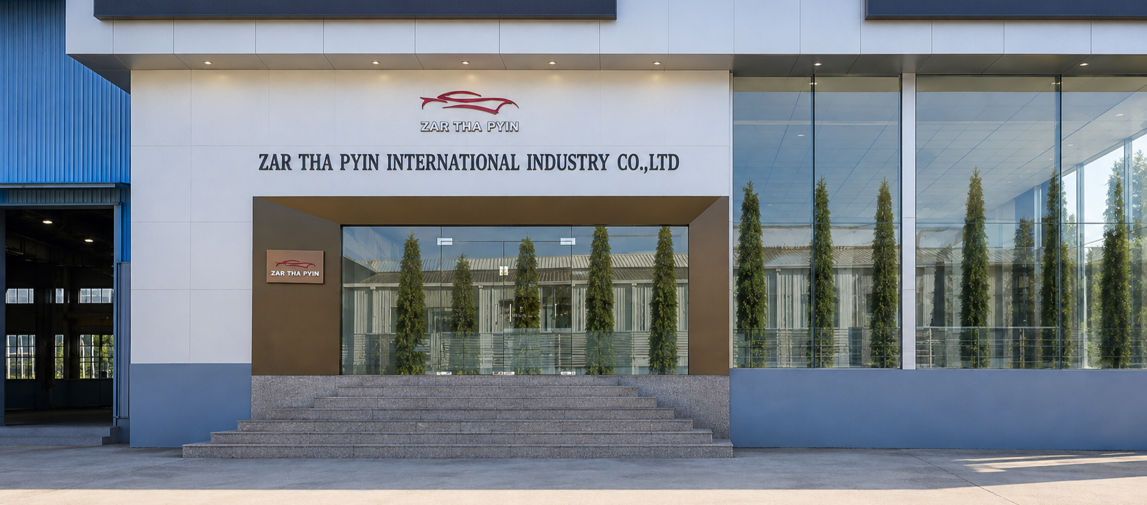 Front view of a modern building with glass windows and white exterior walls, signage reading 'ZAR THA PYIN INTERNATIONAL INDUSTRY CO., LTD,' and a staircase leading up to the entrance.