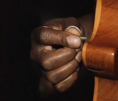 Close-up of a person's hand holding a figurine of a gavel.