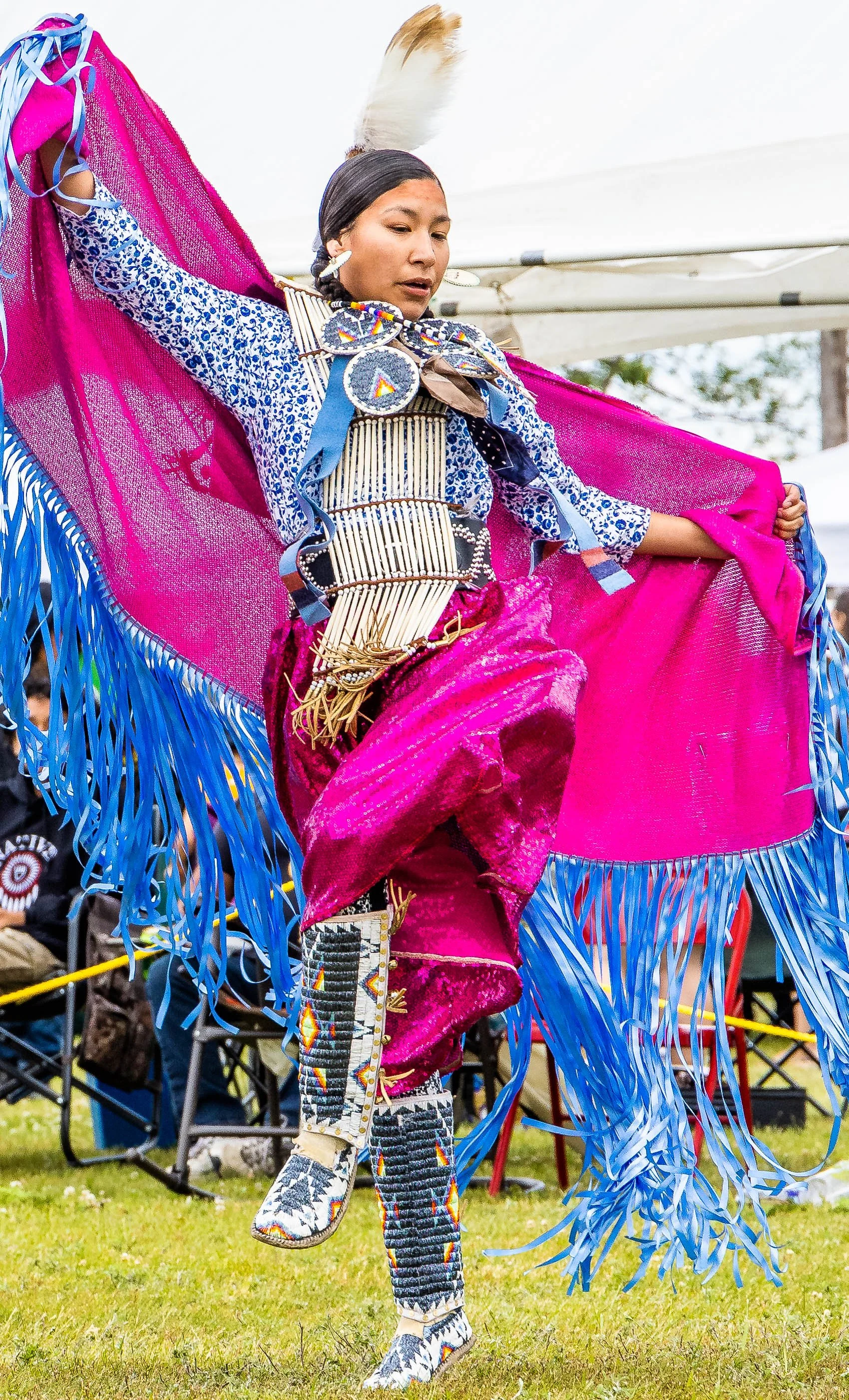 Native dancer in traditional regalia performing at an outdoor event.