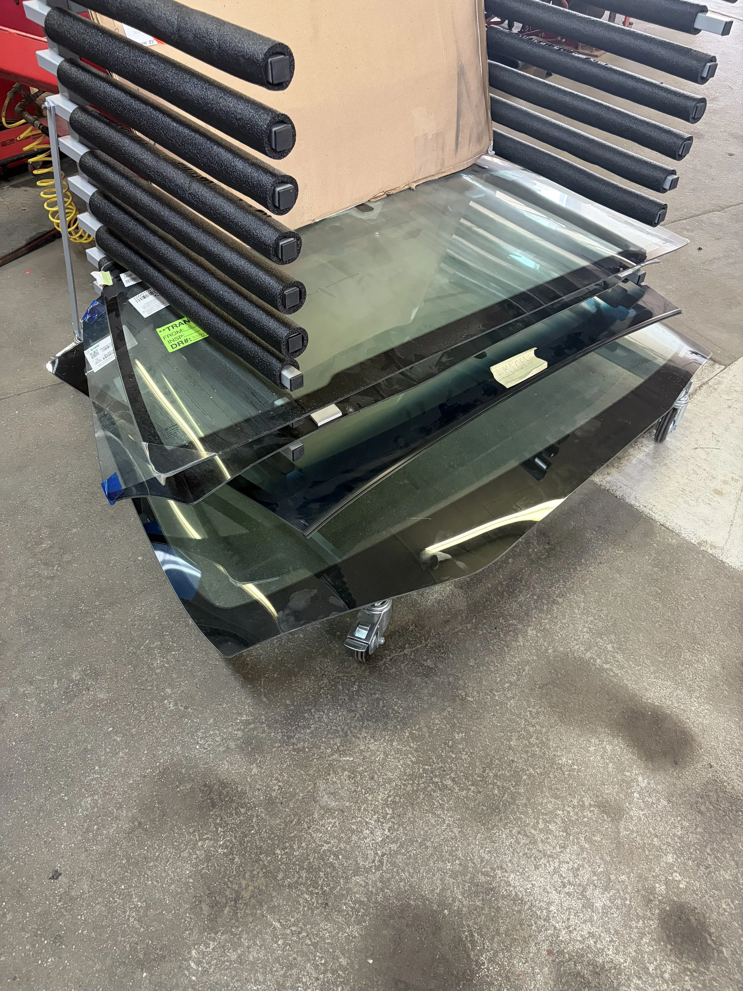 A cart with reflective film sheets stacked on top of it in a workshop setting.
