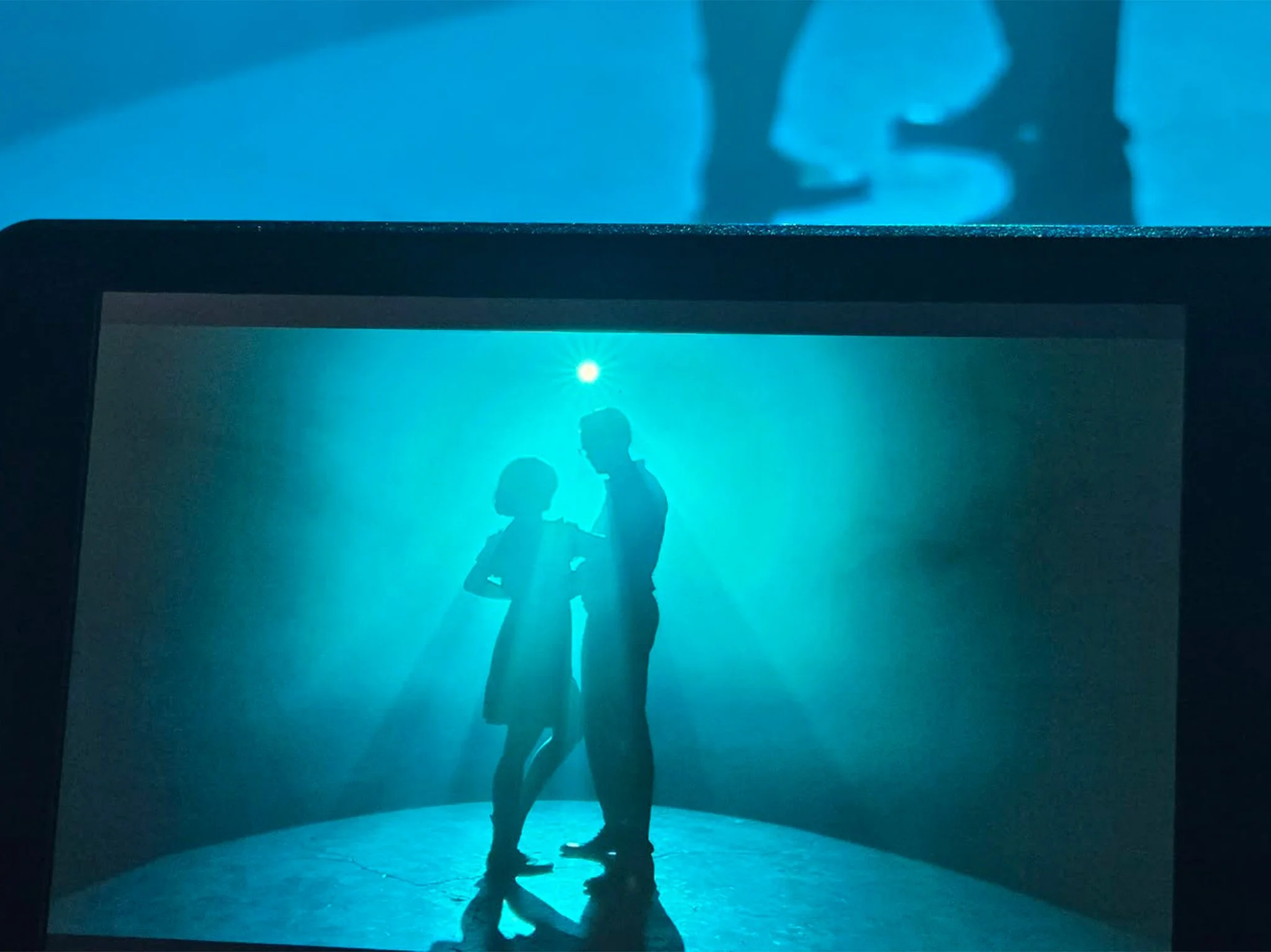 Corpus Christi Behind the Scenes Film Crew of Silhouette of two people kissing in front of a blue background with a framed screen showing their silhouette.