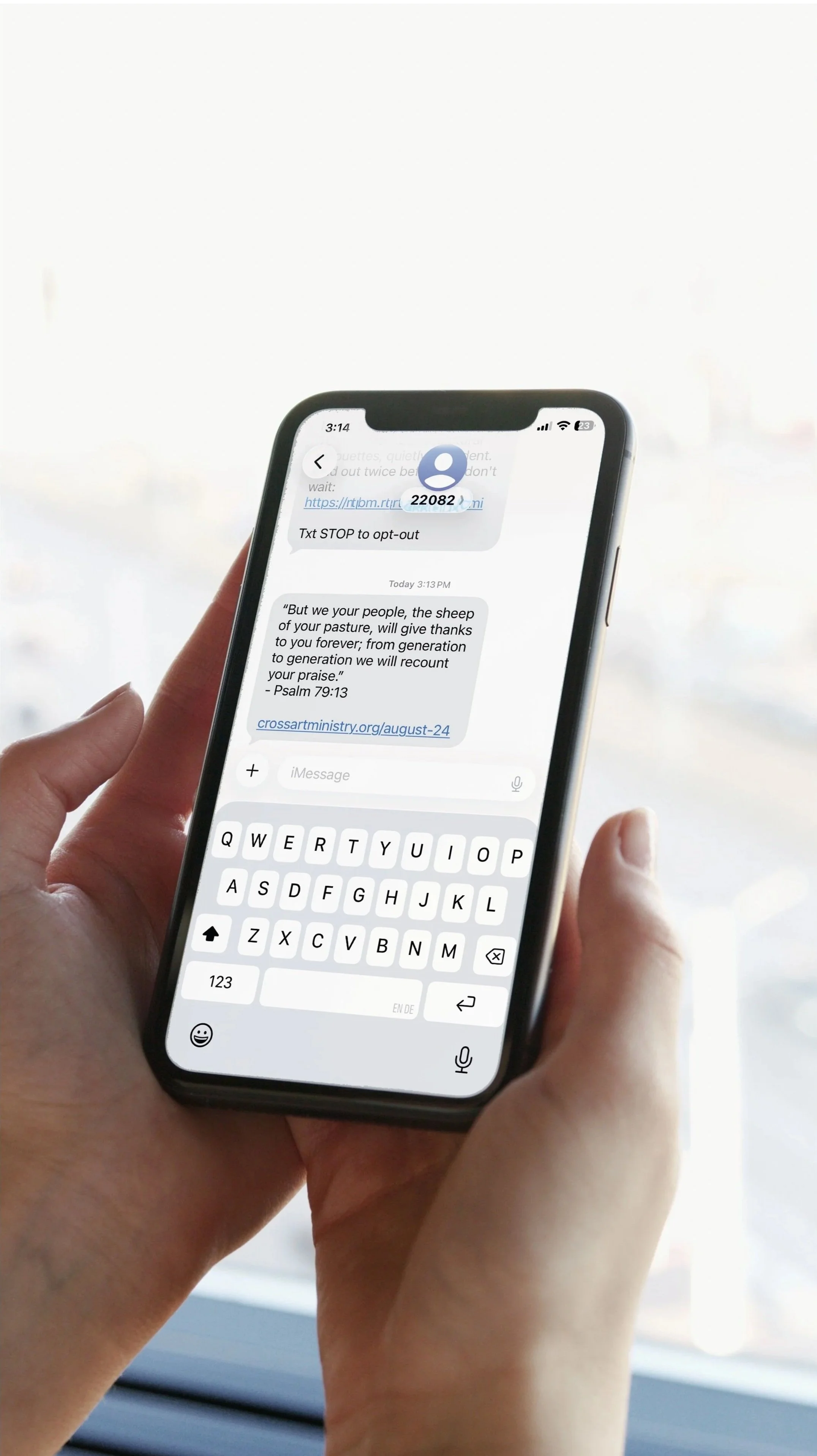 A person holding a smartphone displaying a text message conversation, with a white background and a website URL.