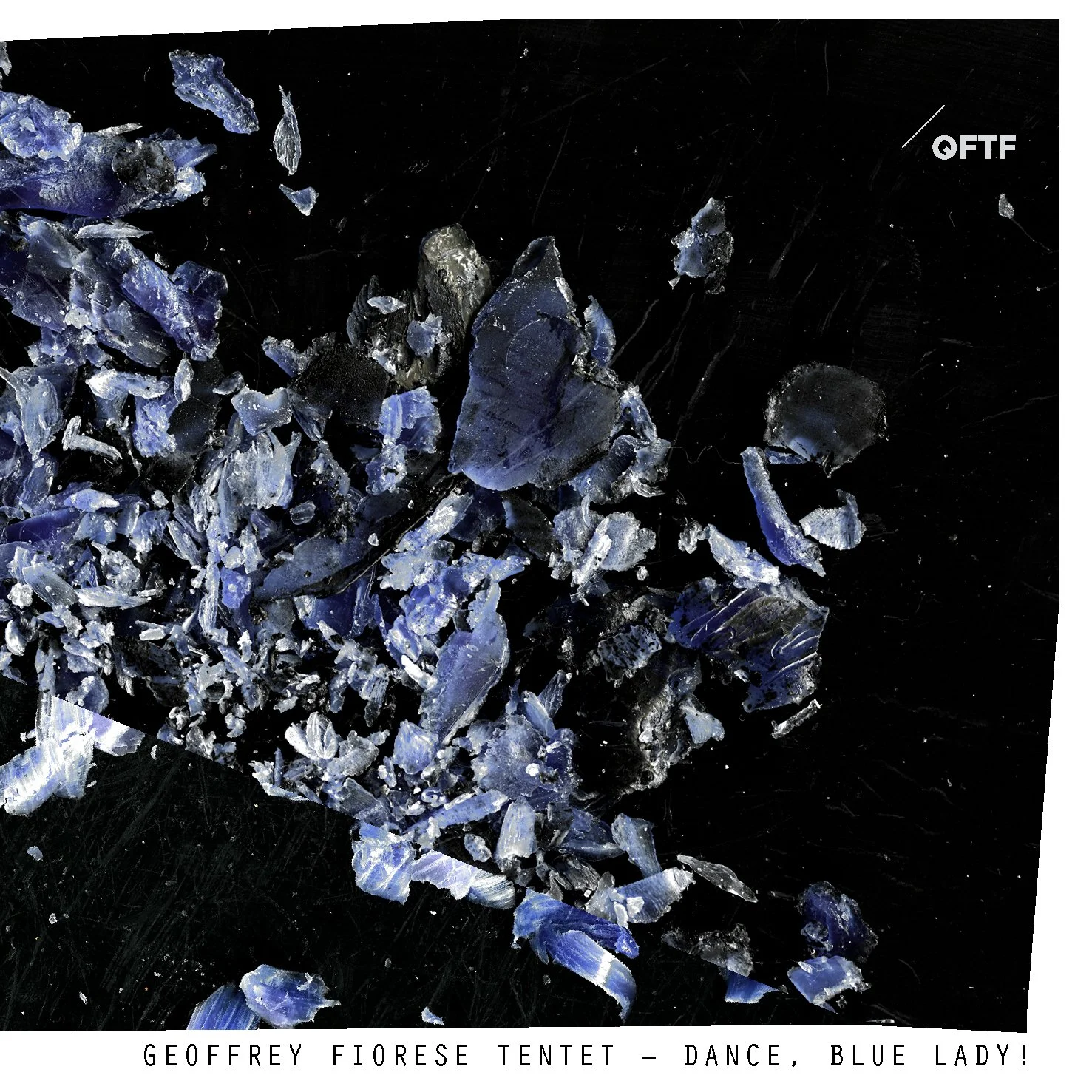 Close-up of shattered blue glass pieces arranged on a black surface, with the text 'GEOFFREY FIORESE TENTET - DANCE, BLUE LADY!' at the bottom.