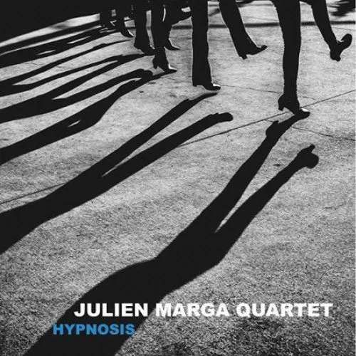Shadows of people walking on a sidewalk with their legs visible, cast long on the ground.
