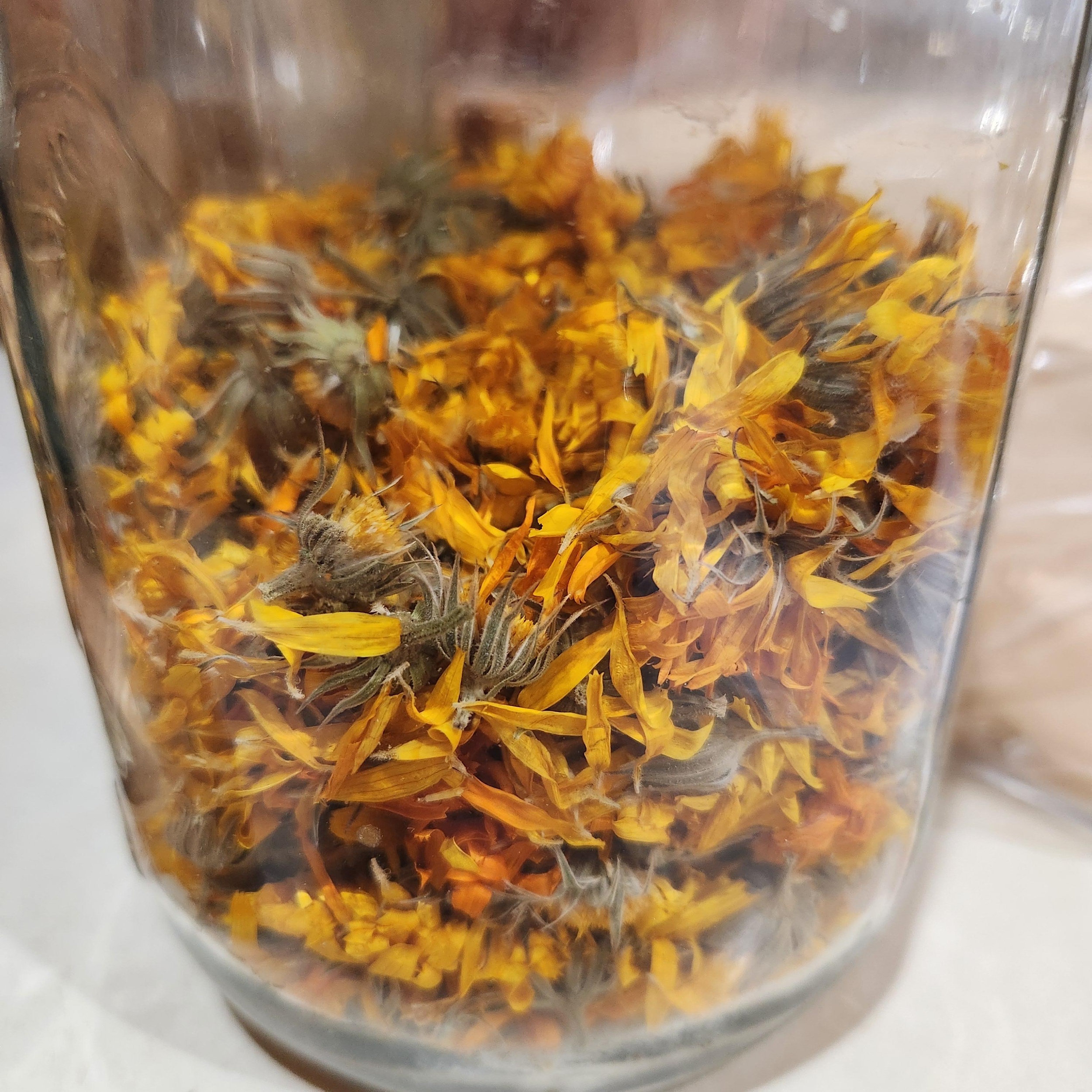 Close-up view of dried sunflower petals and flower heads inside a glass container.