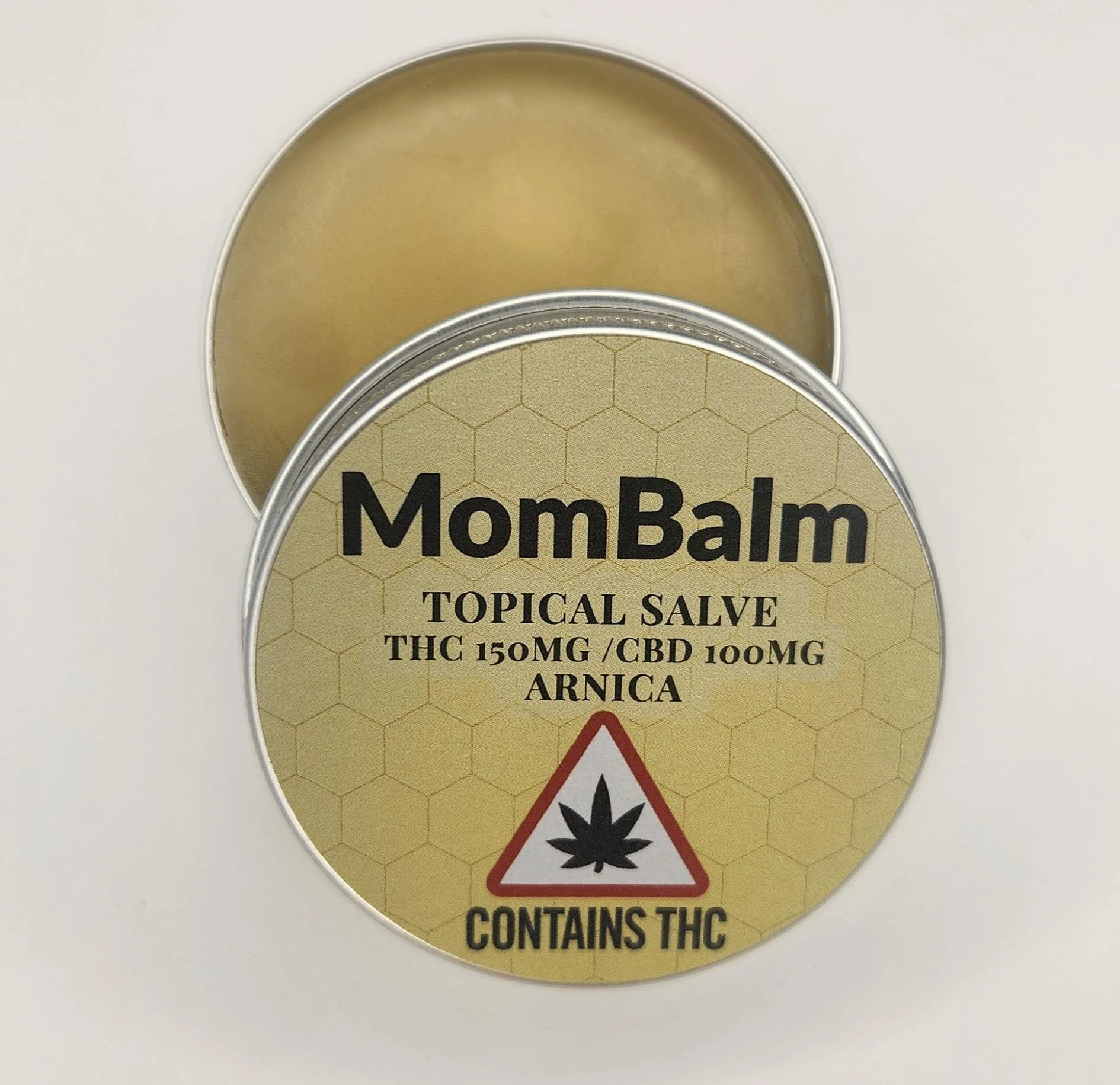 A metal container lid with a cannabis warning label indicating it contains THC and CBD, featuring a marijuana leaf symbol and a caution triangle.