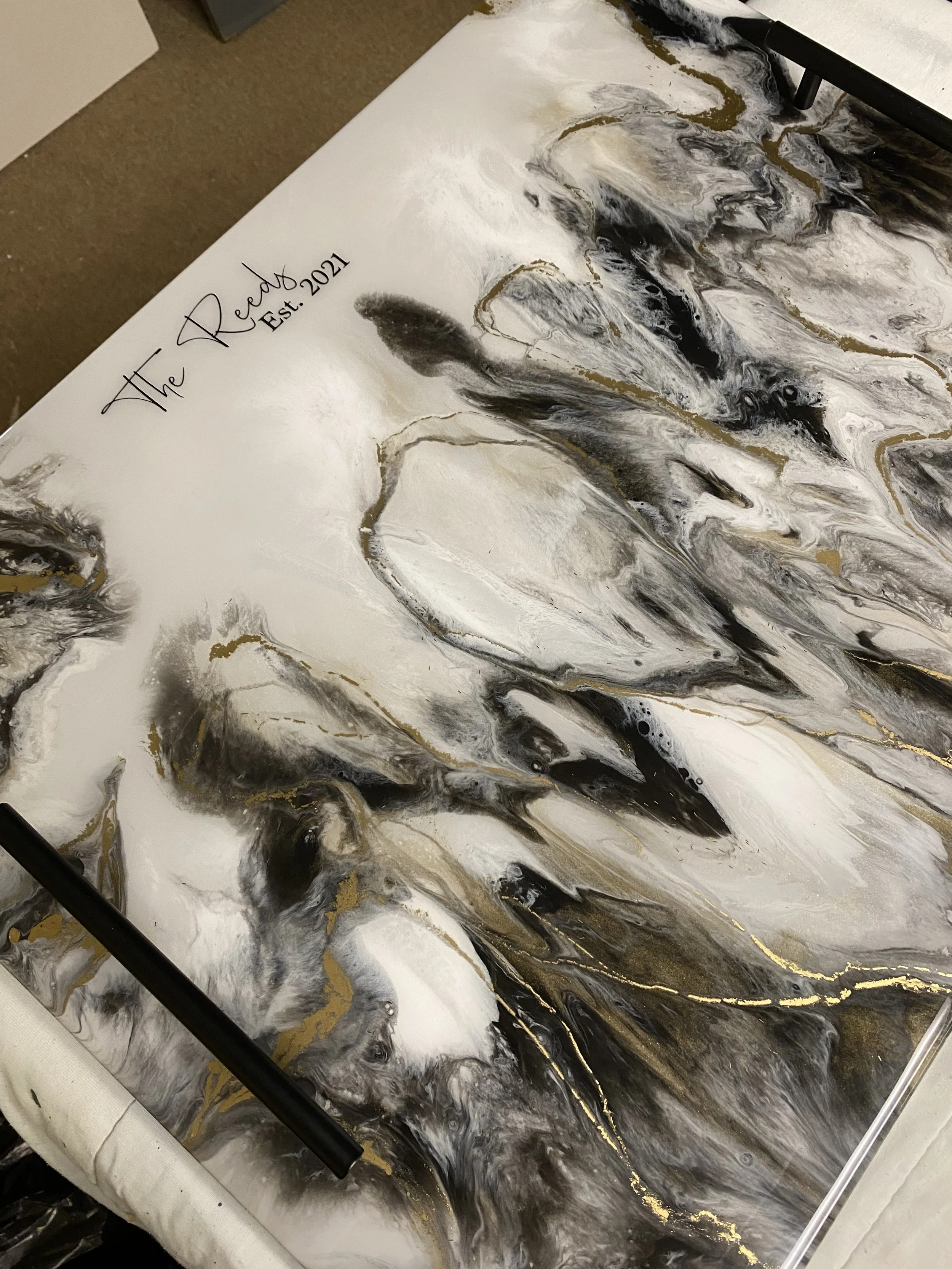Abstract black, white, and gold marble-inspired artwork with cursive text reading 'The Ready Est. 2021' in the upper left corner.