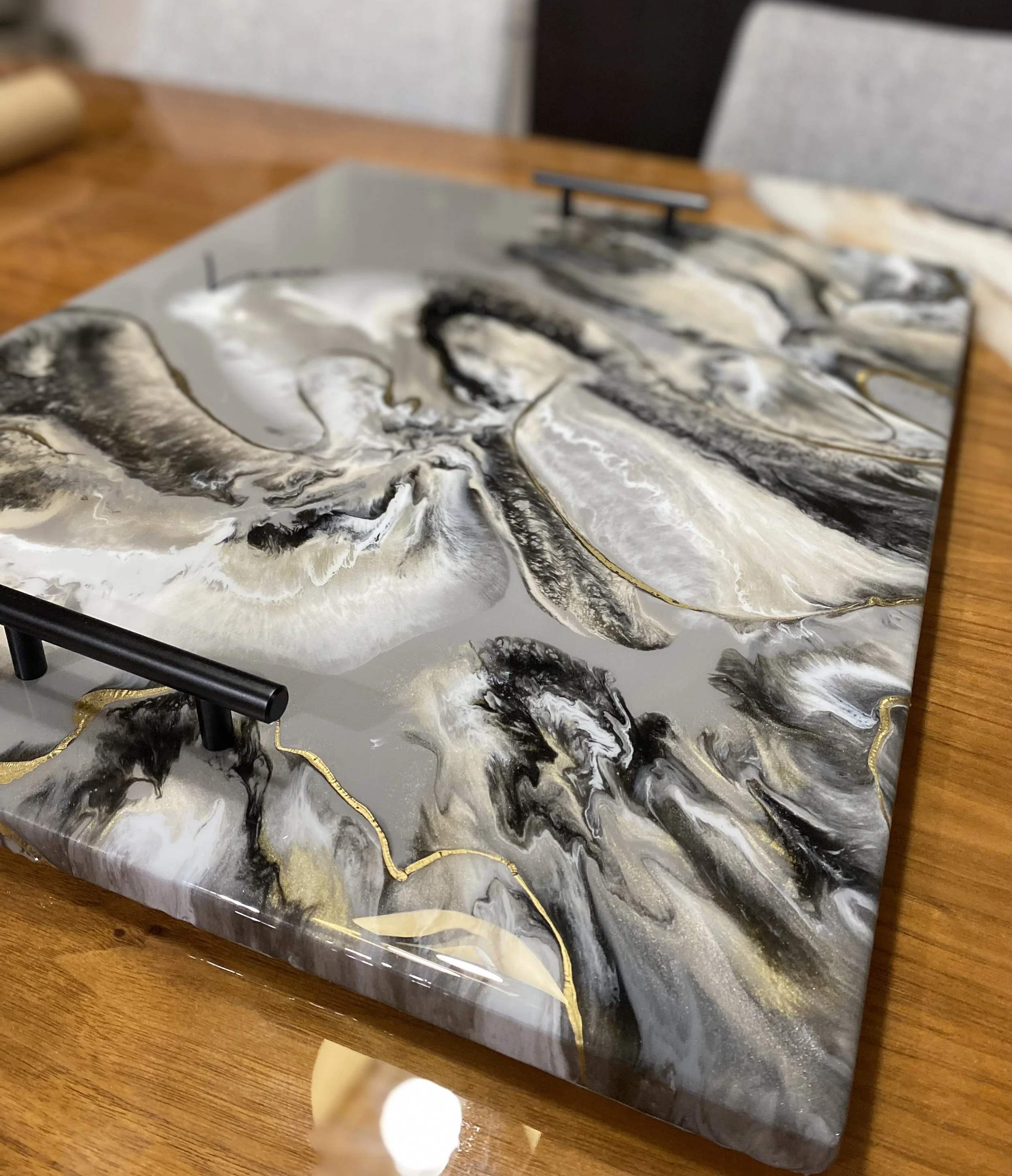 Marble table with black, white, gray, and gold swirling patterns.