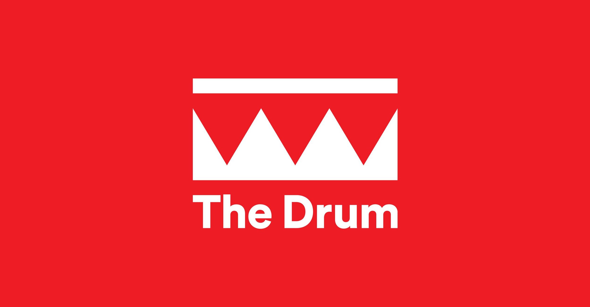 Red background with a white rectangle containing three triangular shapes resembling a stylized drum or sound waves, and beneath it the white text "The Drum."