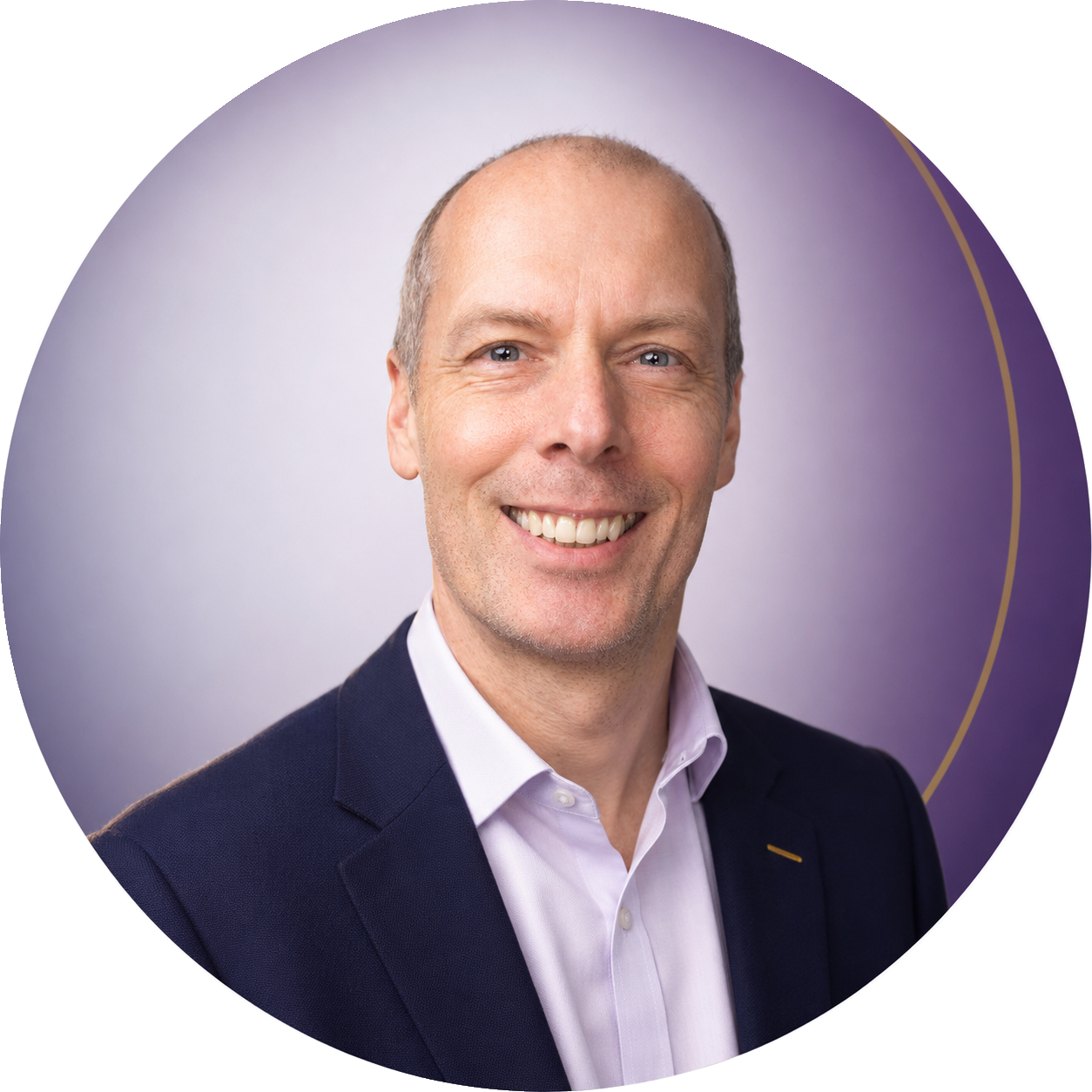A smiling middle-aged man with a bald head and light skin, wearing a dark suit and a light purple dress shirt, posing against a purple and white background.