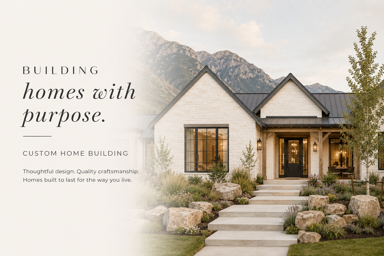 Modern custom home with white brick exterior, black accents, and a landscaped front yard with rocks and plants, set against a mountainous backdrop.