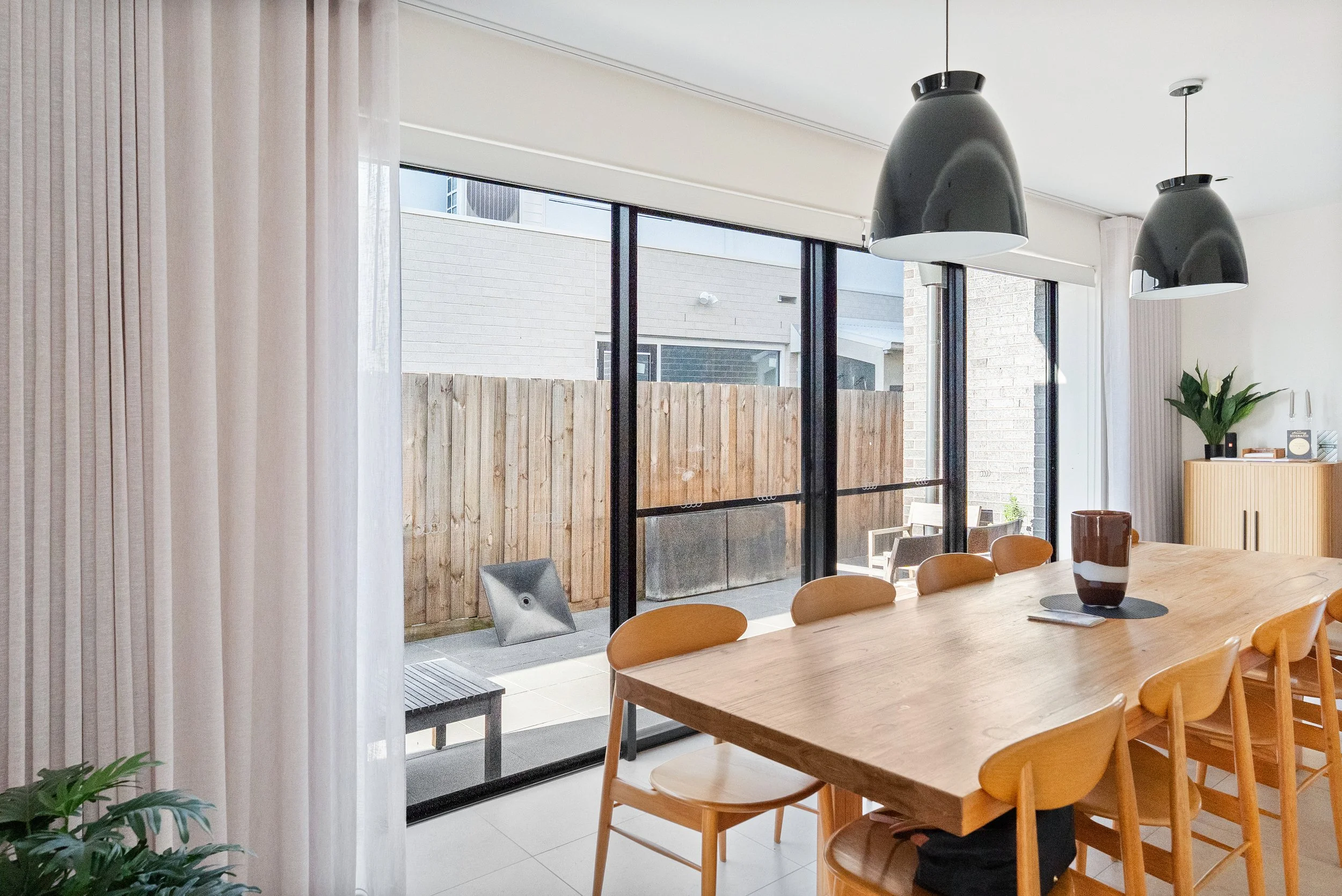 Curtain stacked back beside open sliding doors in the dining area