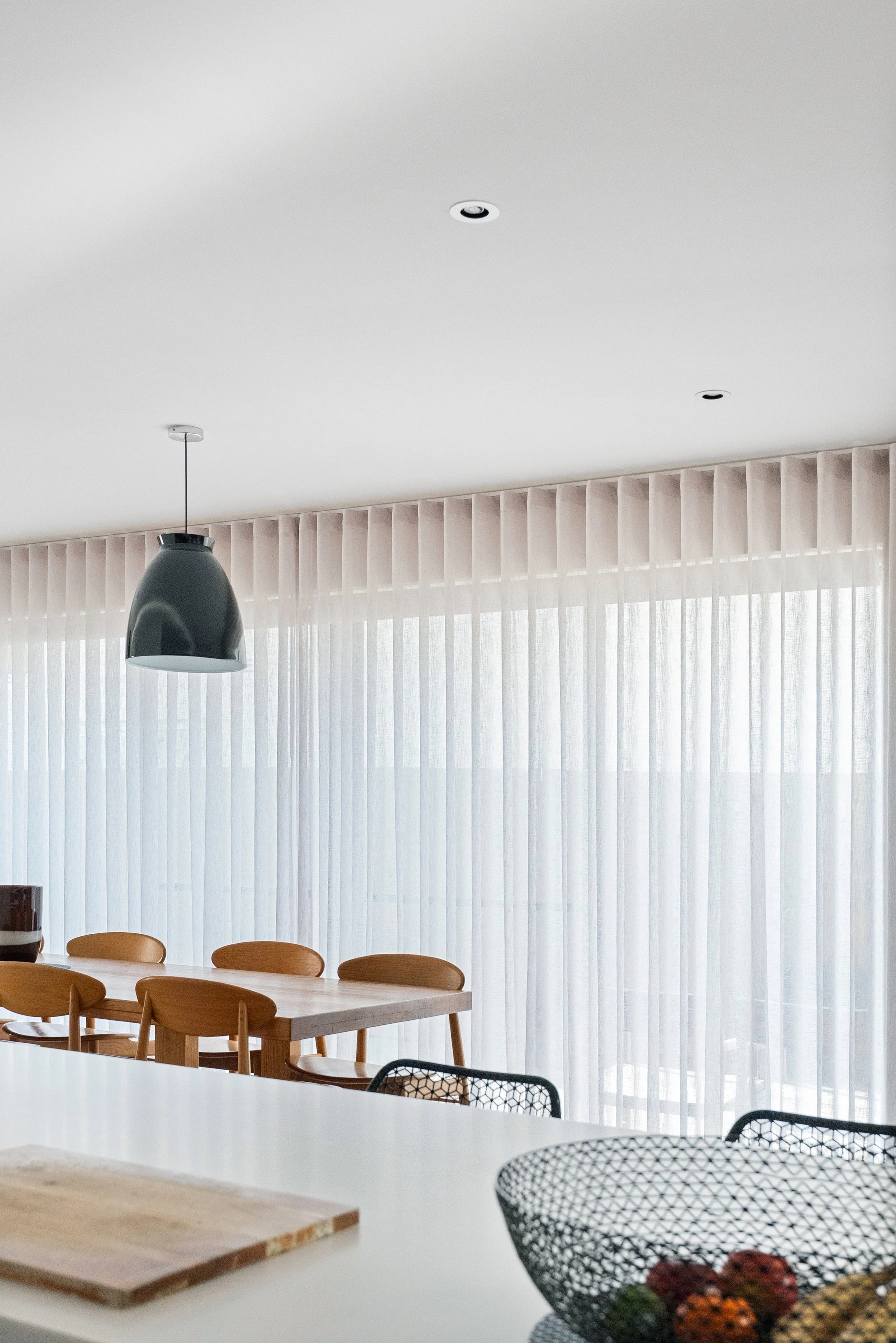 Kitchen and dining area with full-height sheer curtains closed