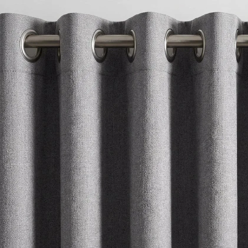 Eyelet curtain heading on a metal rod, grey fabric