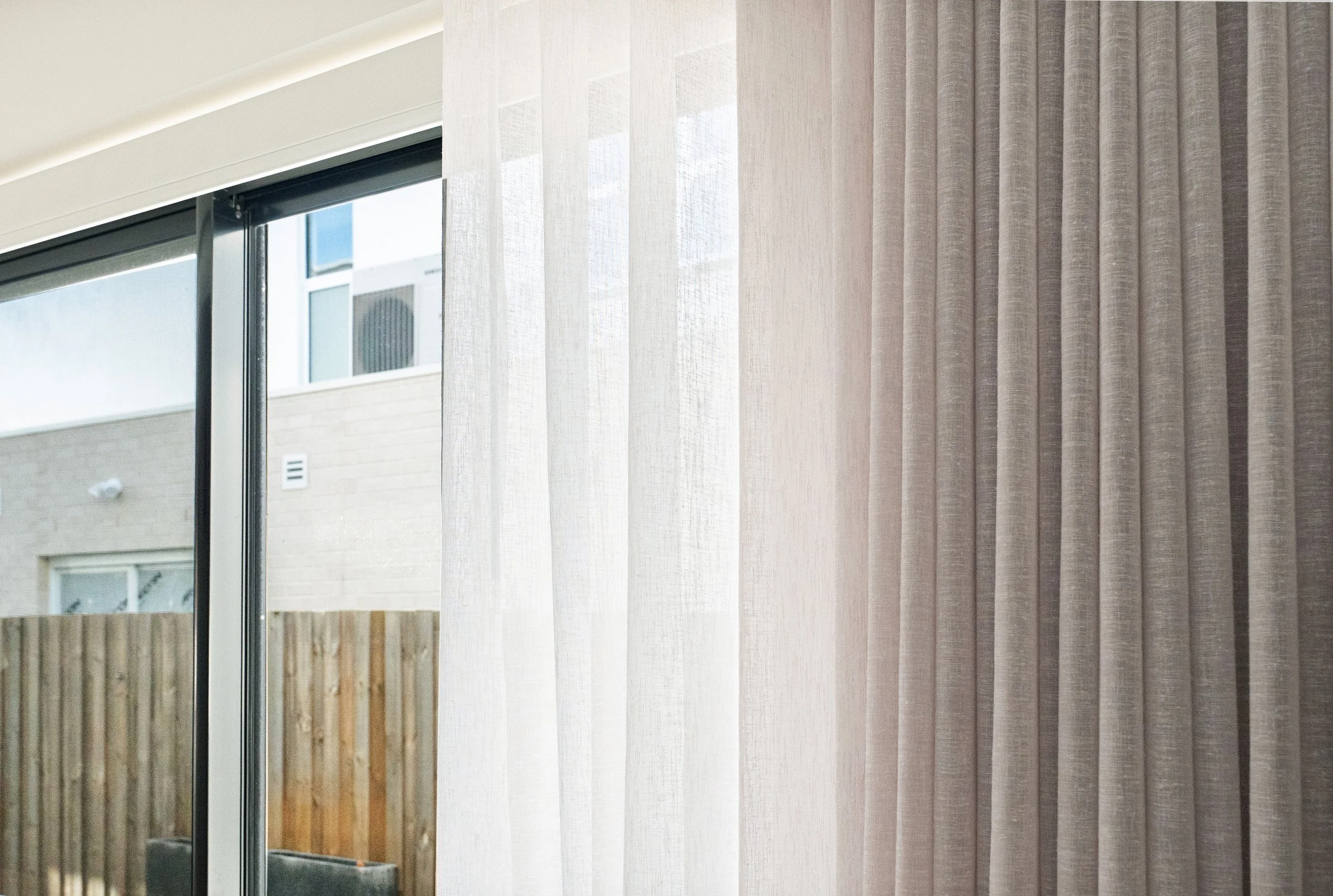 Double curtains in a Spotswood home: a white sheer beside a textured grey curtain