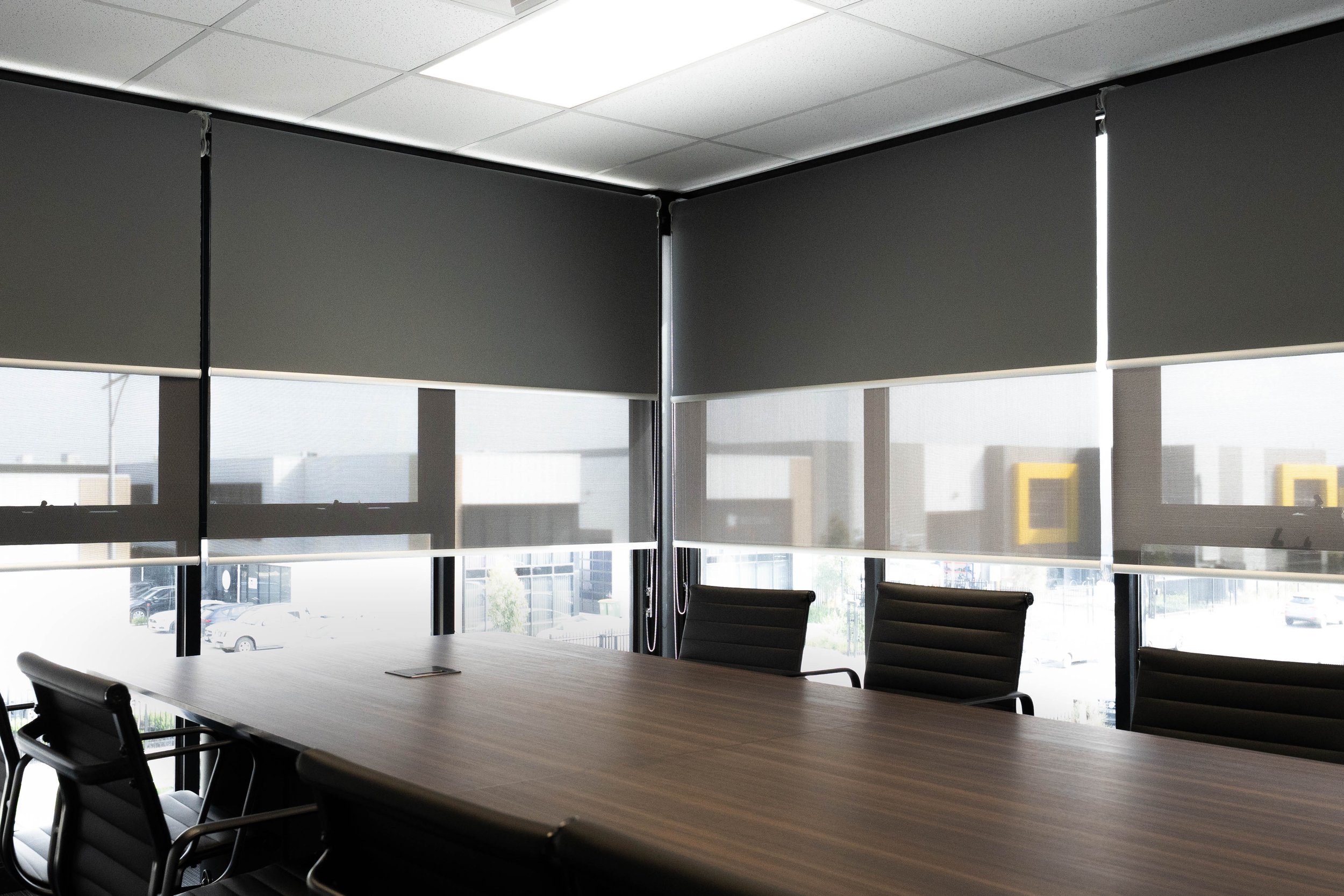 Double roller blinds part-lowered across the boardroom windows