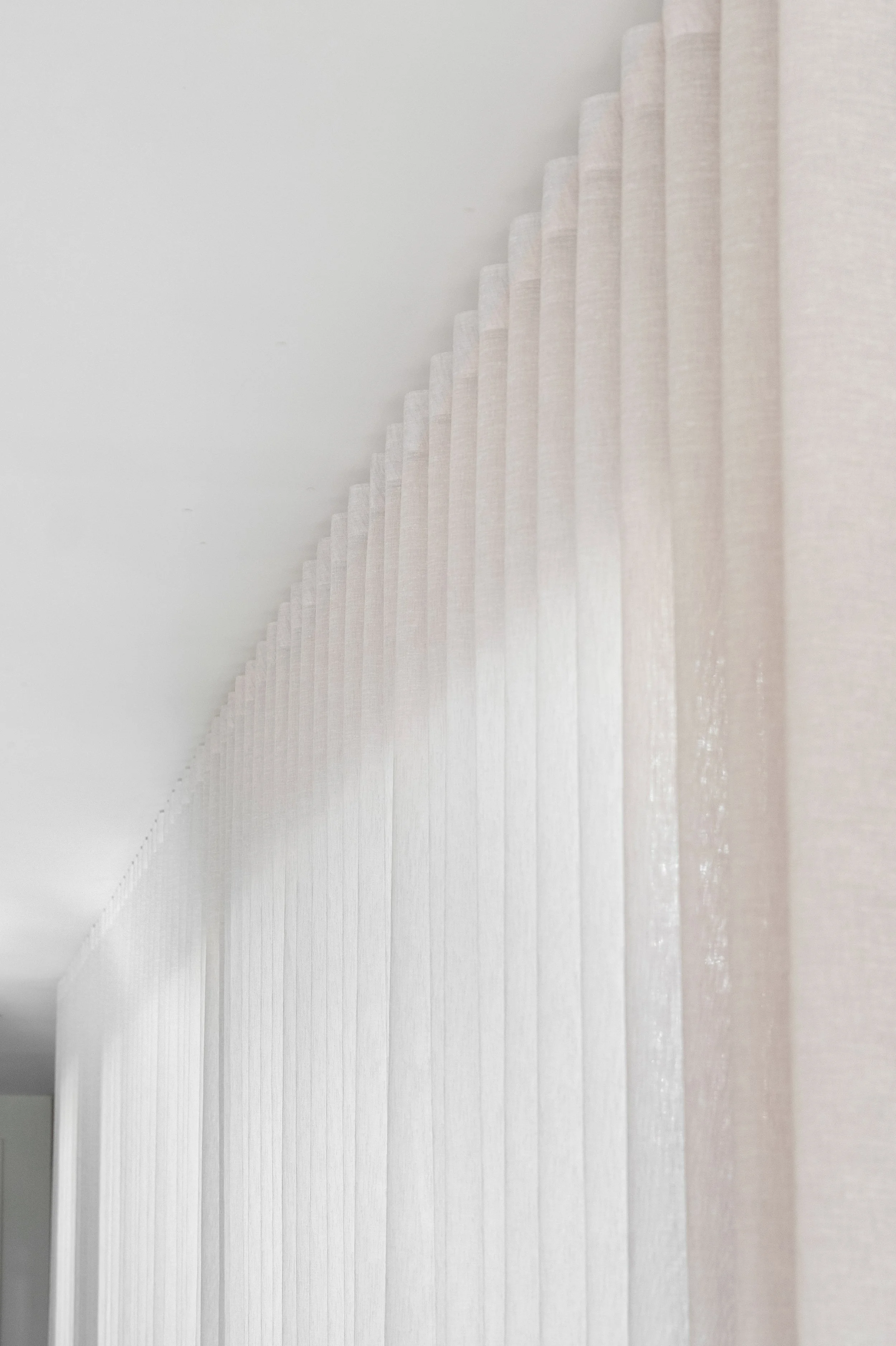 Looking along a wall of full-height sheer curtains