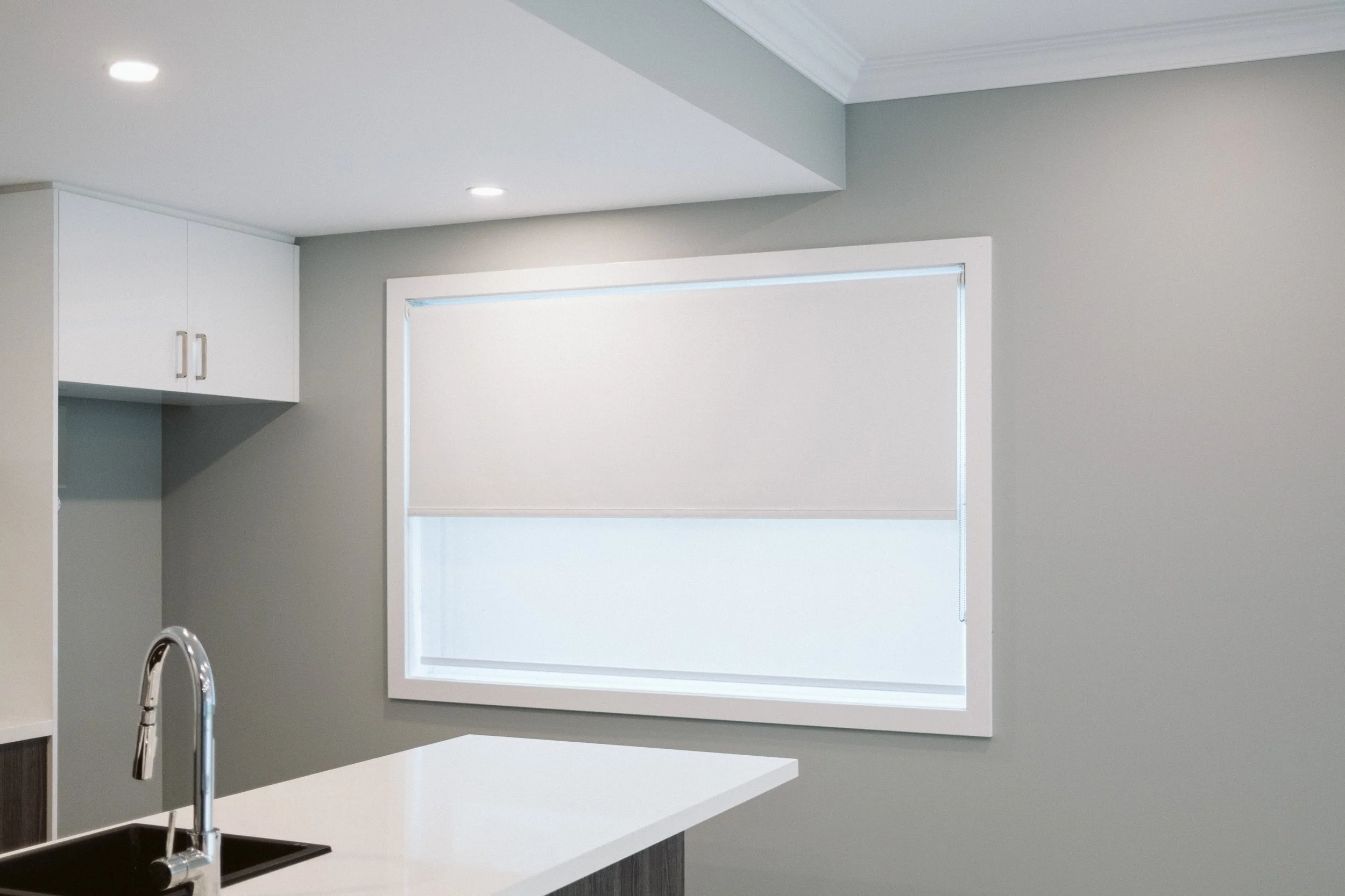 Roller blind part-lowered on a kitchen window in a Williamstown home