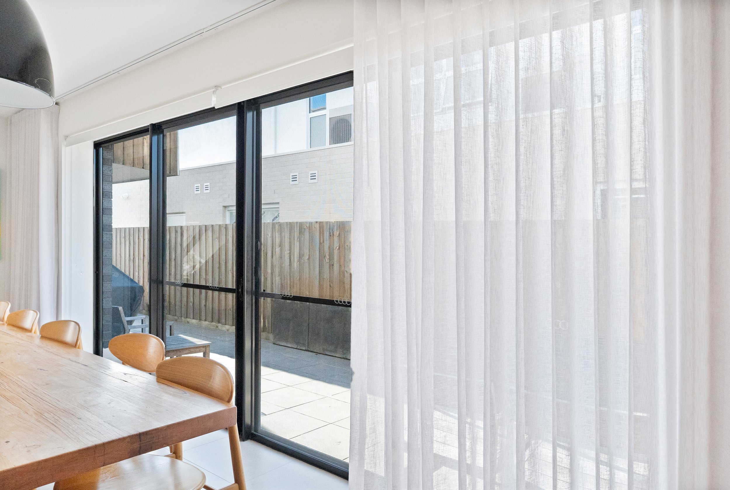 Sheer curtains closed across sliding doors in the dining area