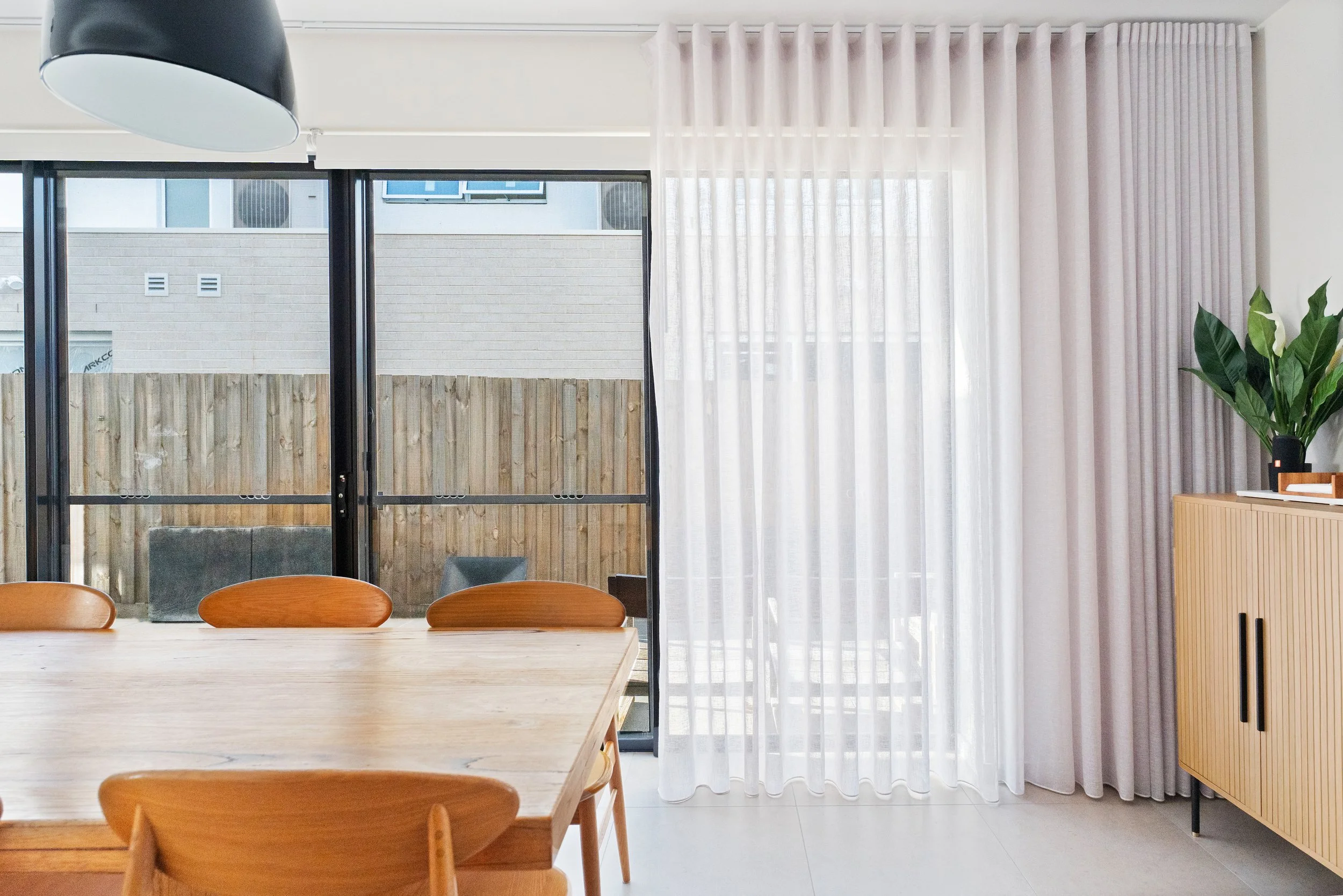 Sheer curtains beside sliding doors in a Spotswood dining room