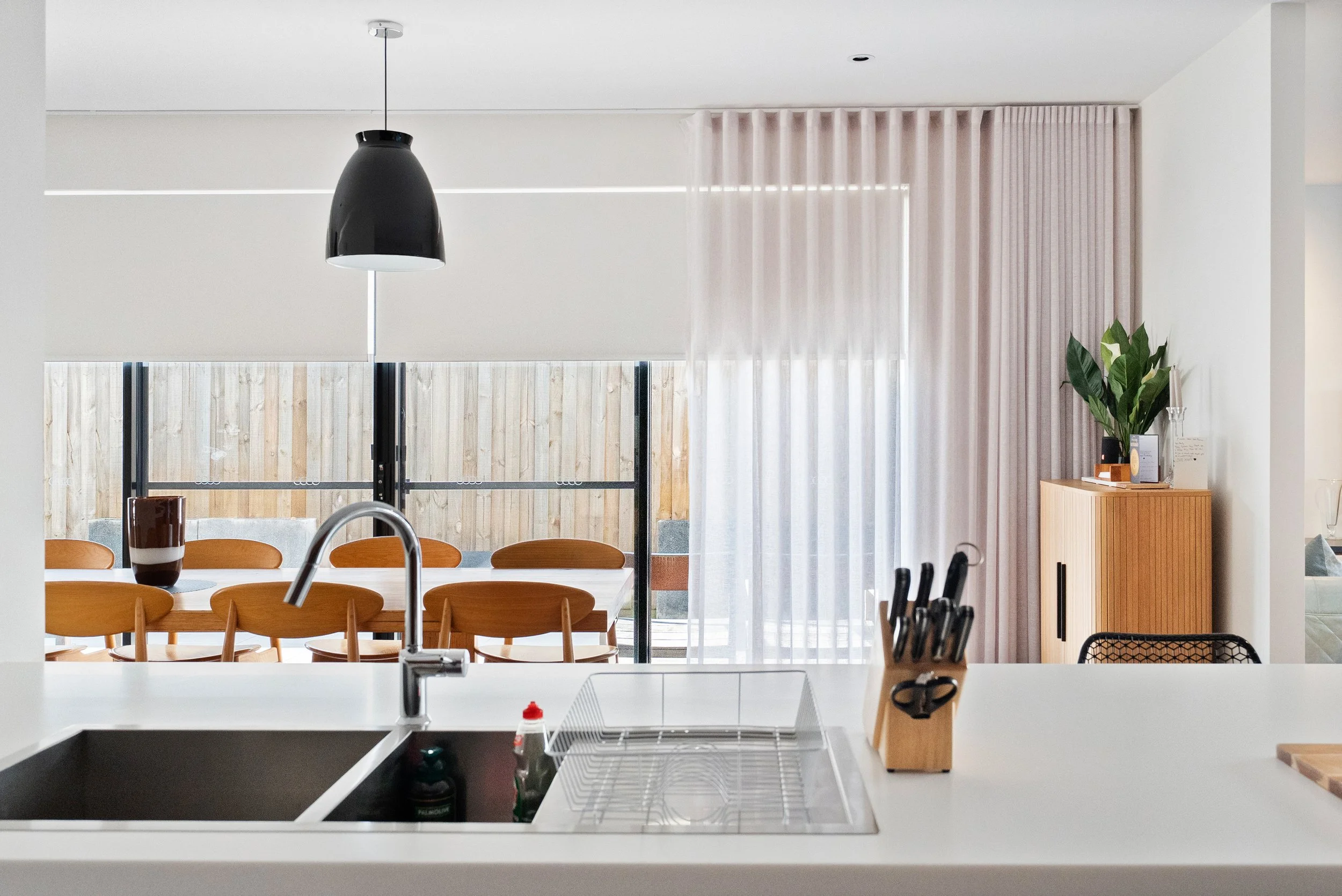 Roller blinds and sheer curtains in the kitchen and dining area of a Spotswood home