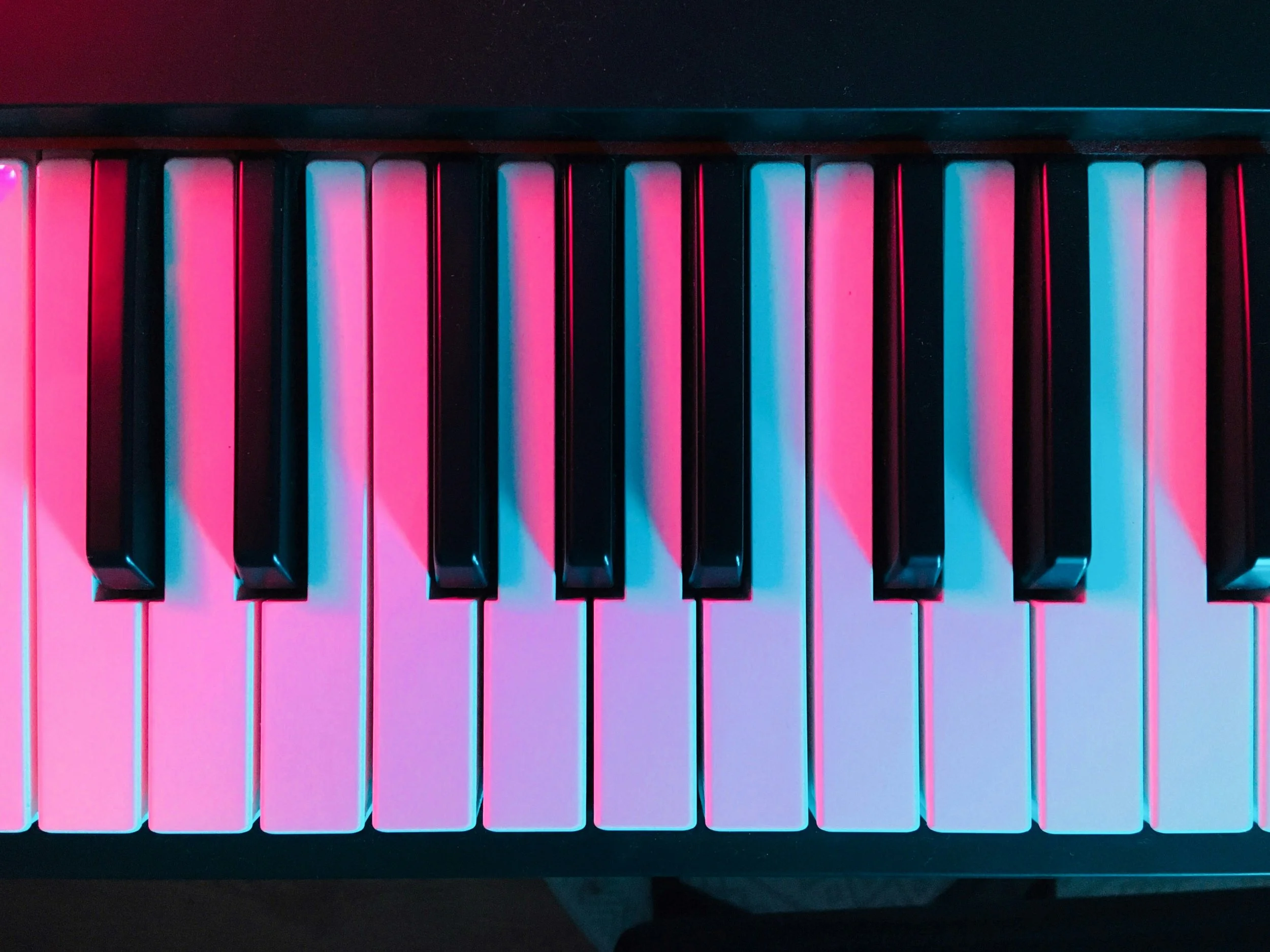 close-up of piano keys in pink light