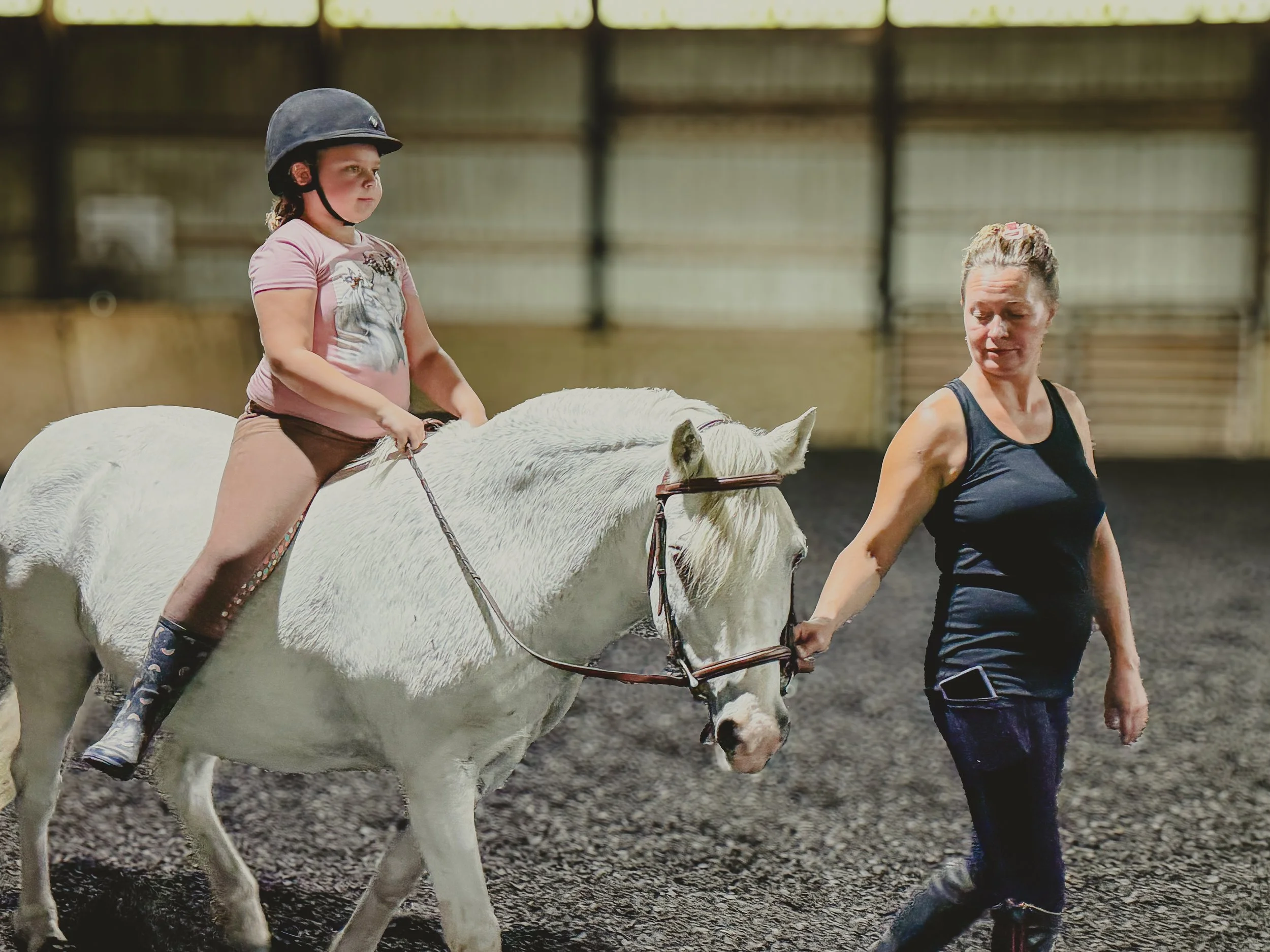 Daun Hohman guiding a young rider during a lesson