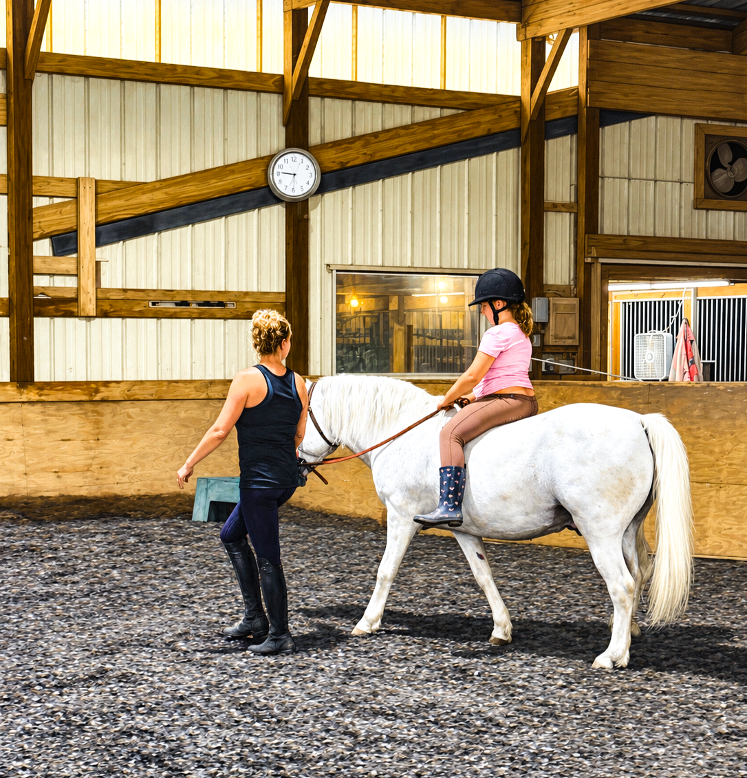 Child riding a white horse with an instructor at Shallow Creek Stables