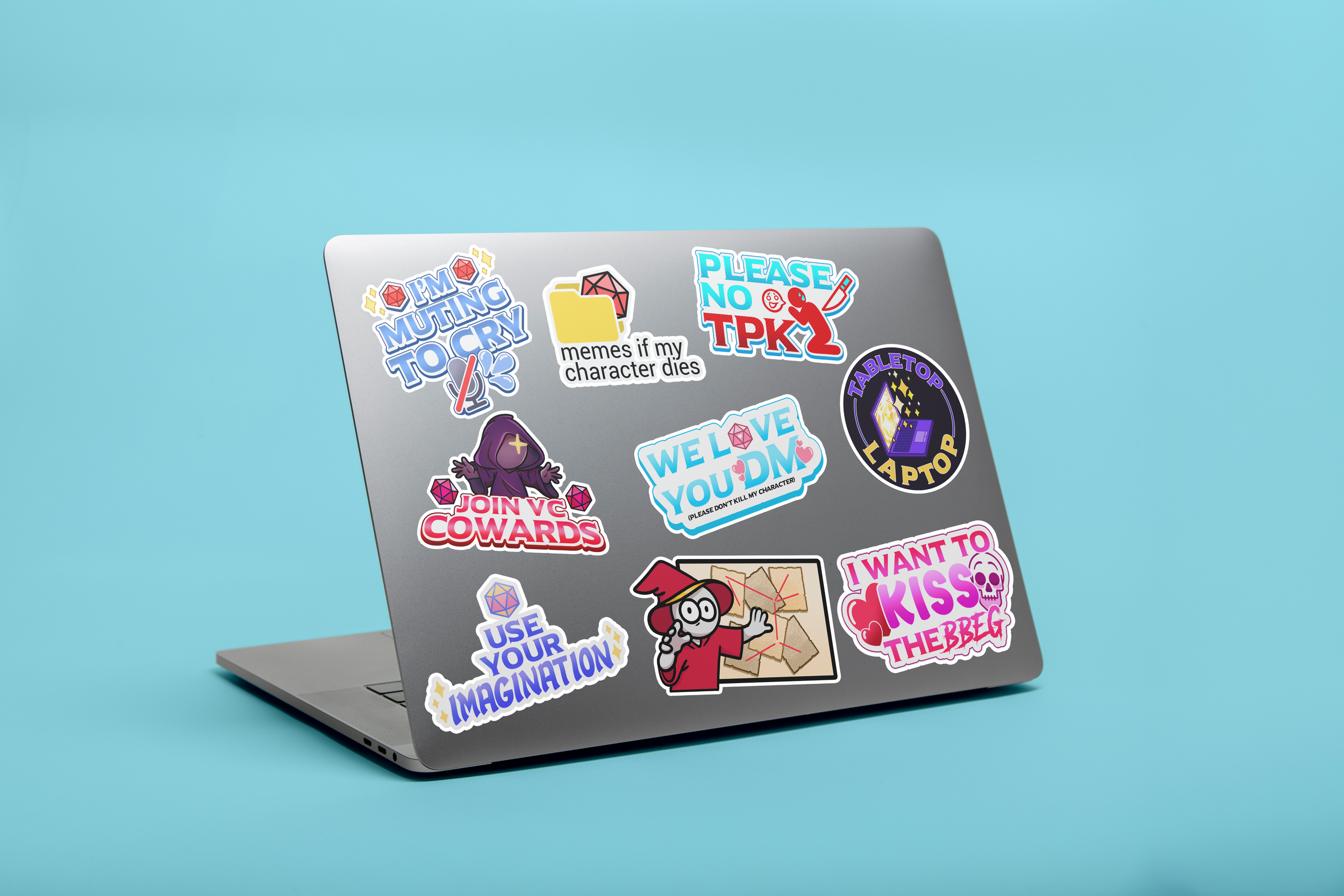 Laptop with colorful stickers, including phrases like "I'm Muting To Cry," "Please No TPK," "Join VC Cowards," "We Love You DM," "Tabletop Laptop," and others, on a light blue background.