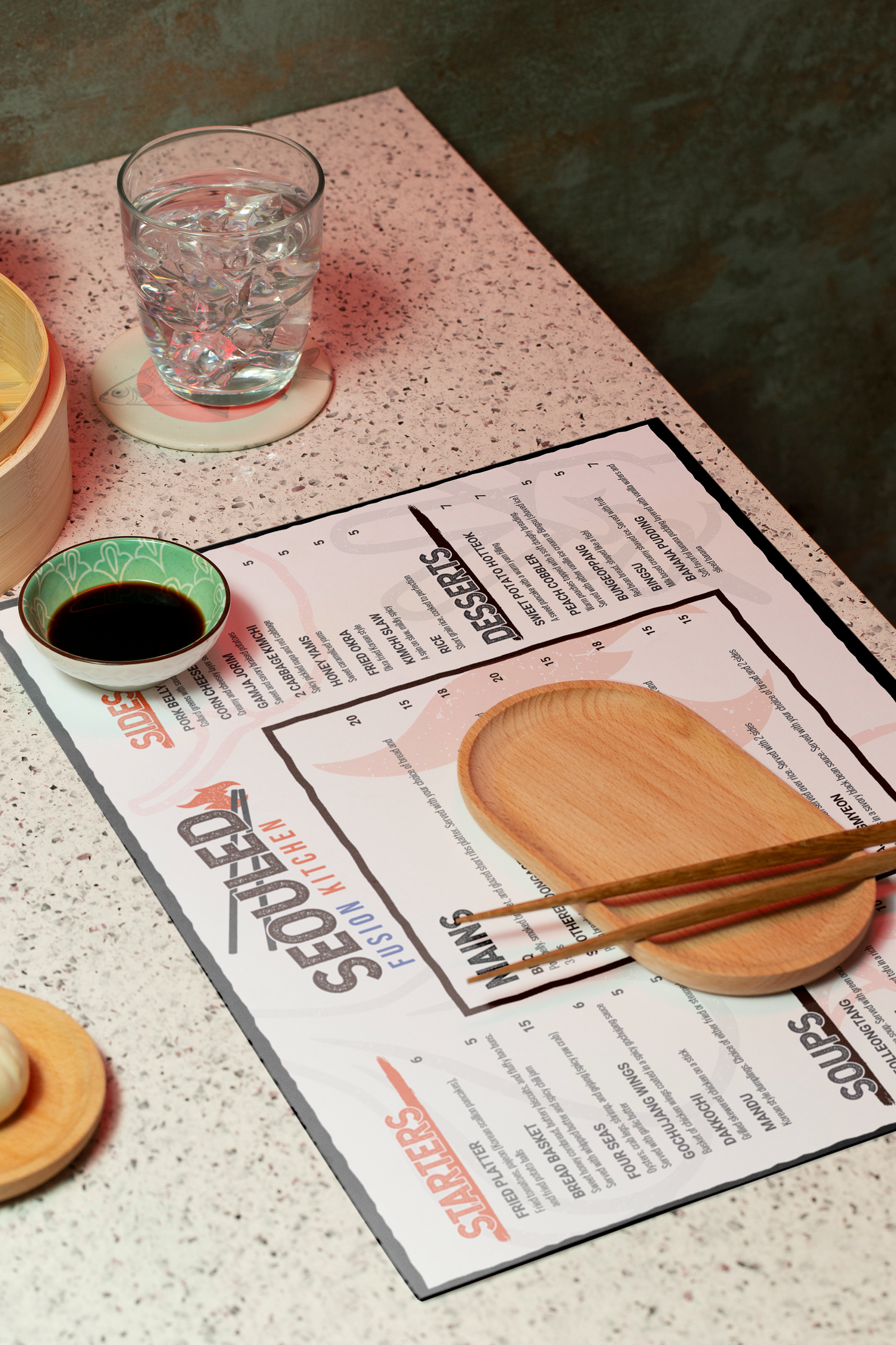 A restaurant menu on a table with a glass of water with ice, a small dish of soy sauce, and wooden chopsticks resting on a round wooden plate.