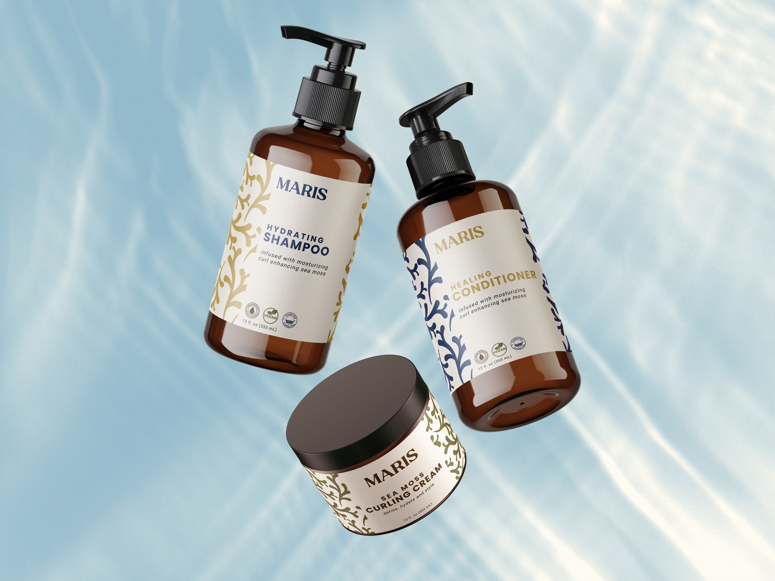Two brown bottles of Maris skincare products, a hydrating shampoo and a healing conditioner, lying on a light blue surface, with their labels facing forward.