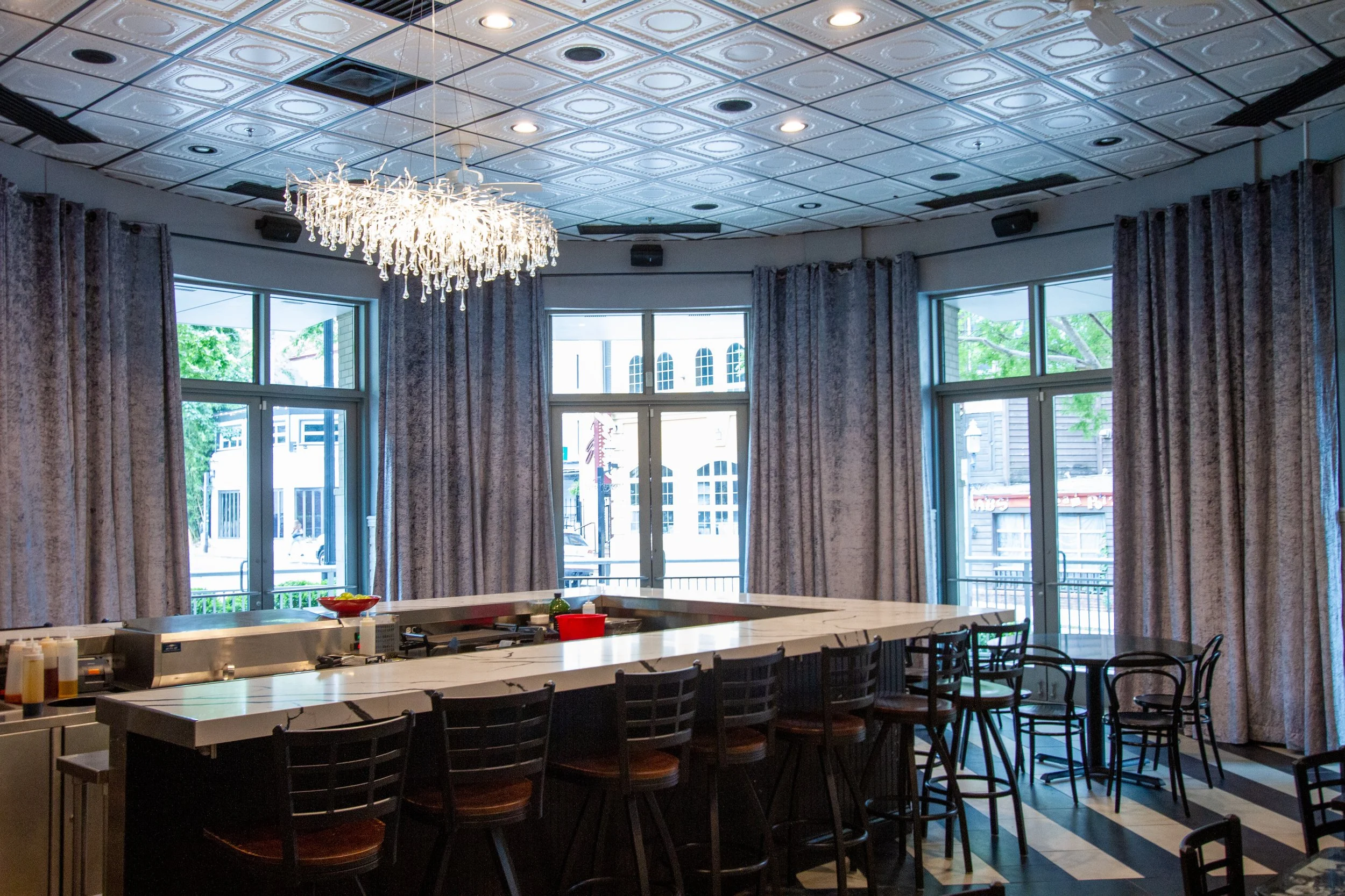 Interior view of a restaurant with large windows featuring custom curtains.