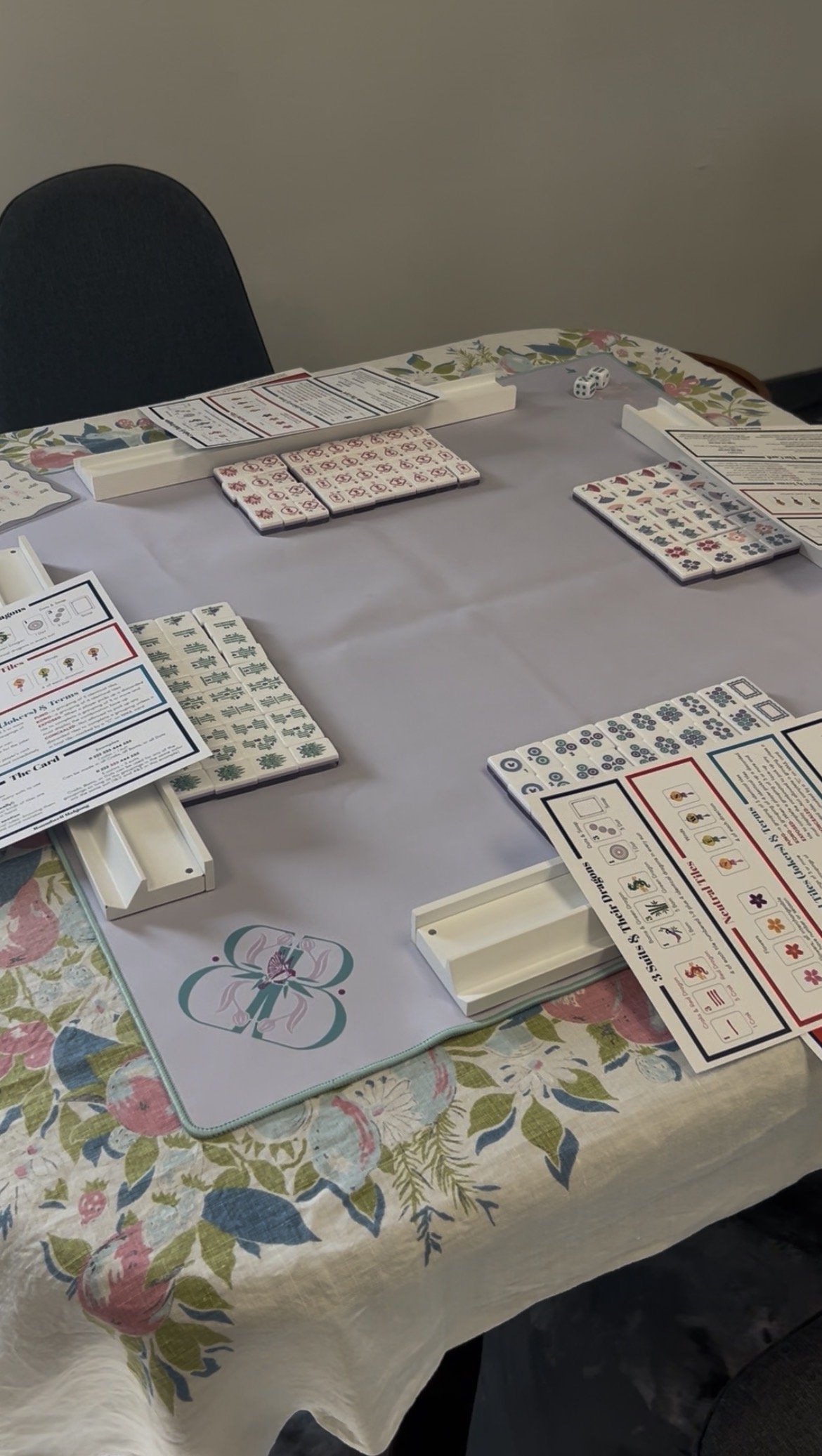 Mahjong table set up with tiles, dice, scorecards and instructional materials for Roundwell Mahjong lesson.