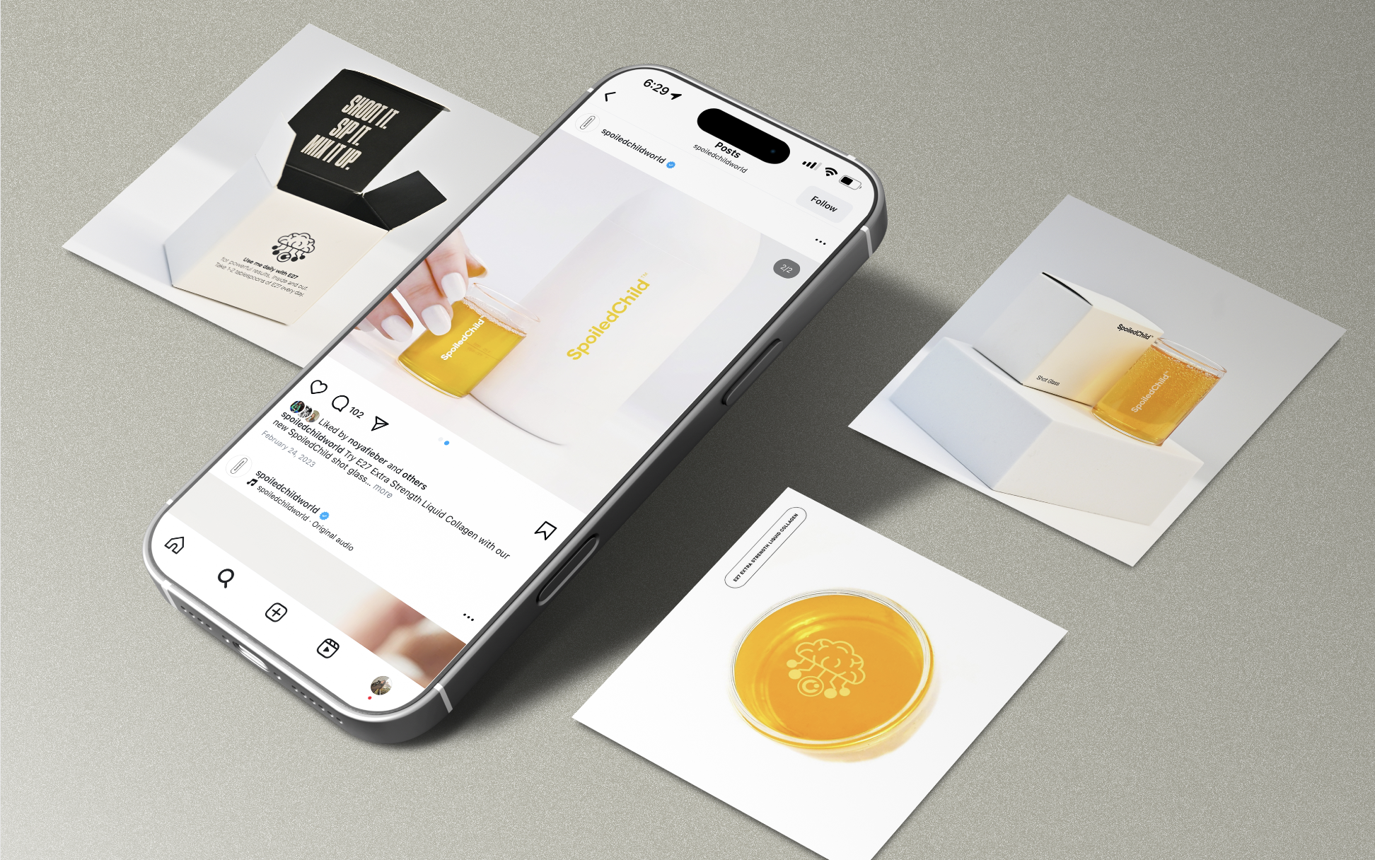 Smartphone displaying an Instagram post of a yellow liquid in a beaker with the word "SpoiledChild" and a yellow brain logo on top of the liquid. The background includes printed material and a small booklet, with some of the printed material showing the phrase "SHOOT IT. SPIT IT. MIX IT UP."