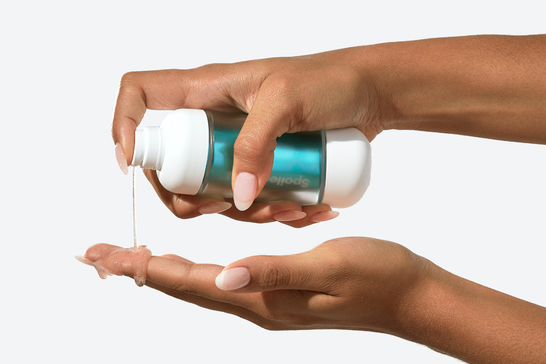 Person dispensing hand sanitizer onto their palm