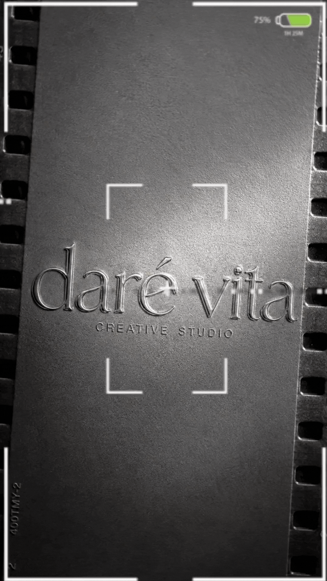 Close-up of a metallic nameplate with the text 'darevita CREATIVE STUDIO' engraved on it, surrounded by a camera frame, with a battery indicator showing 75% in the top right corner.