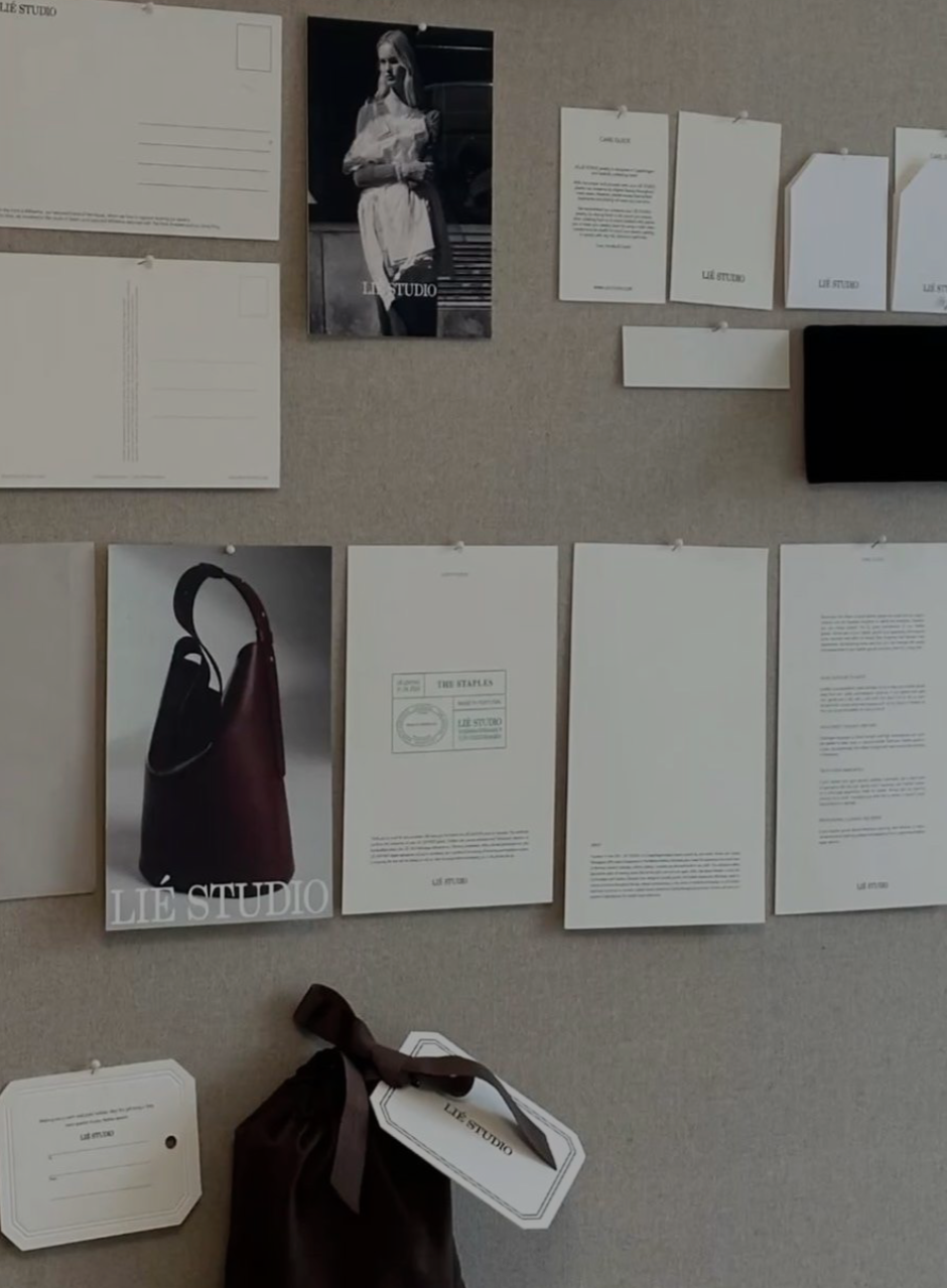 A bulletin board displaying various black-and-white and color images, including a woman in a dress, a handbag, and documents with the label 'LÏE STUDIO'.