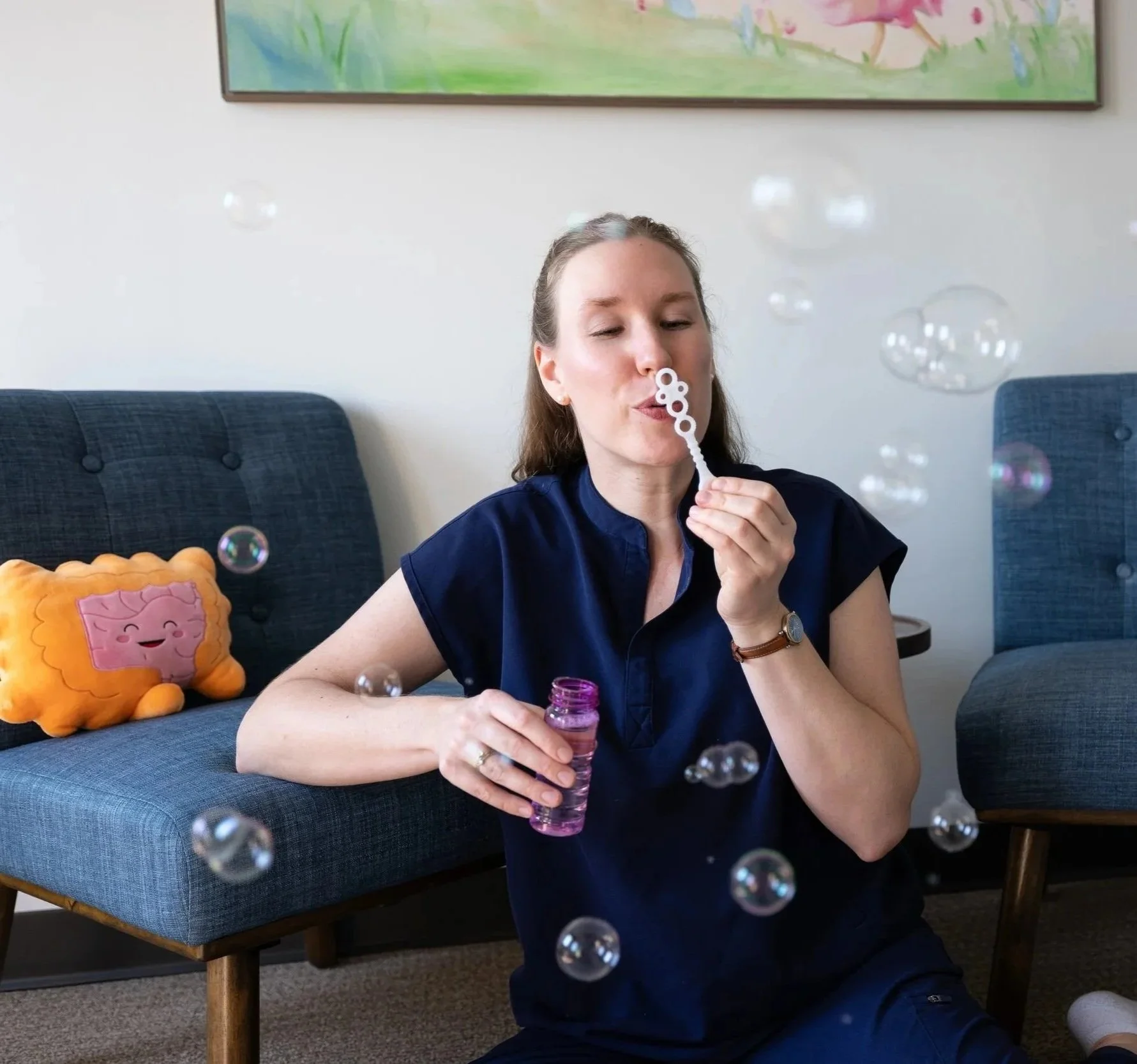 pelvic floor physical therapist blows bubbles to help child with breathing for pediatric pelvic health therapy