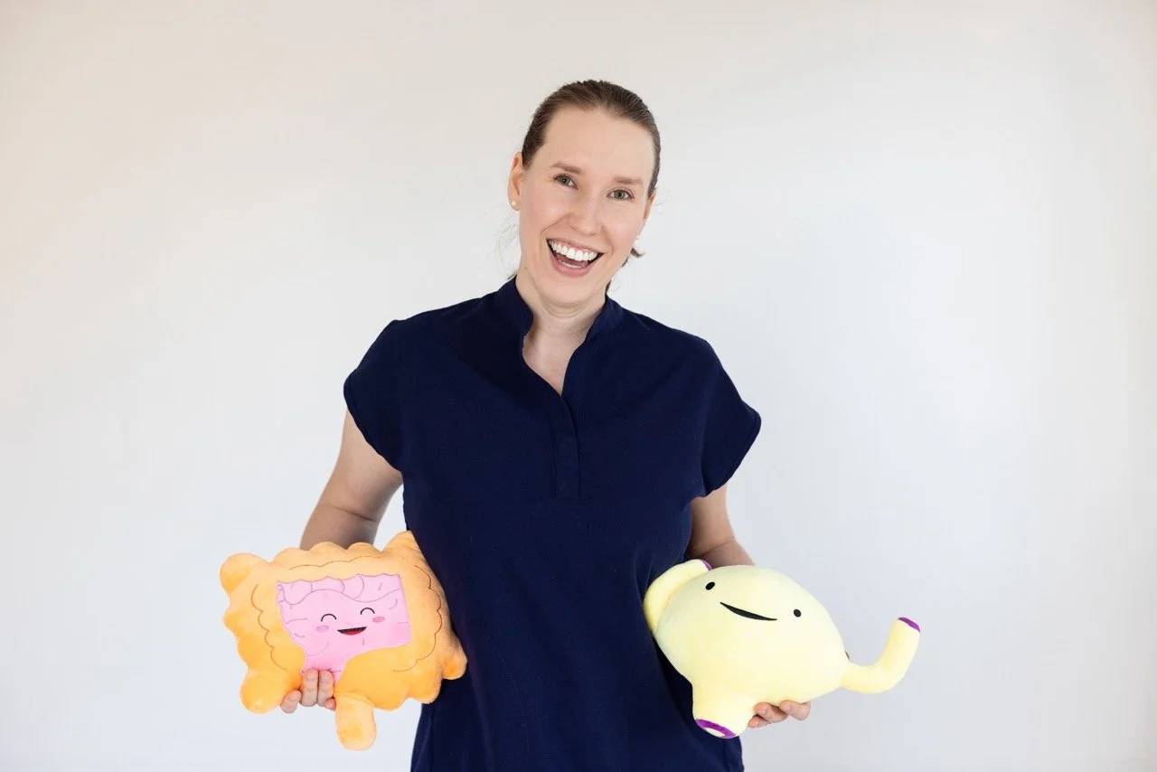 Dr. Savannah holds plush bowel and bladder toys used in pediatric pelvic health therapy