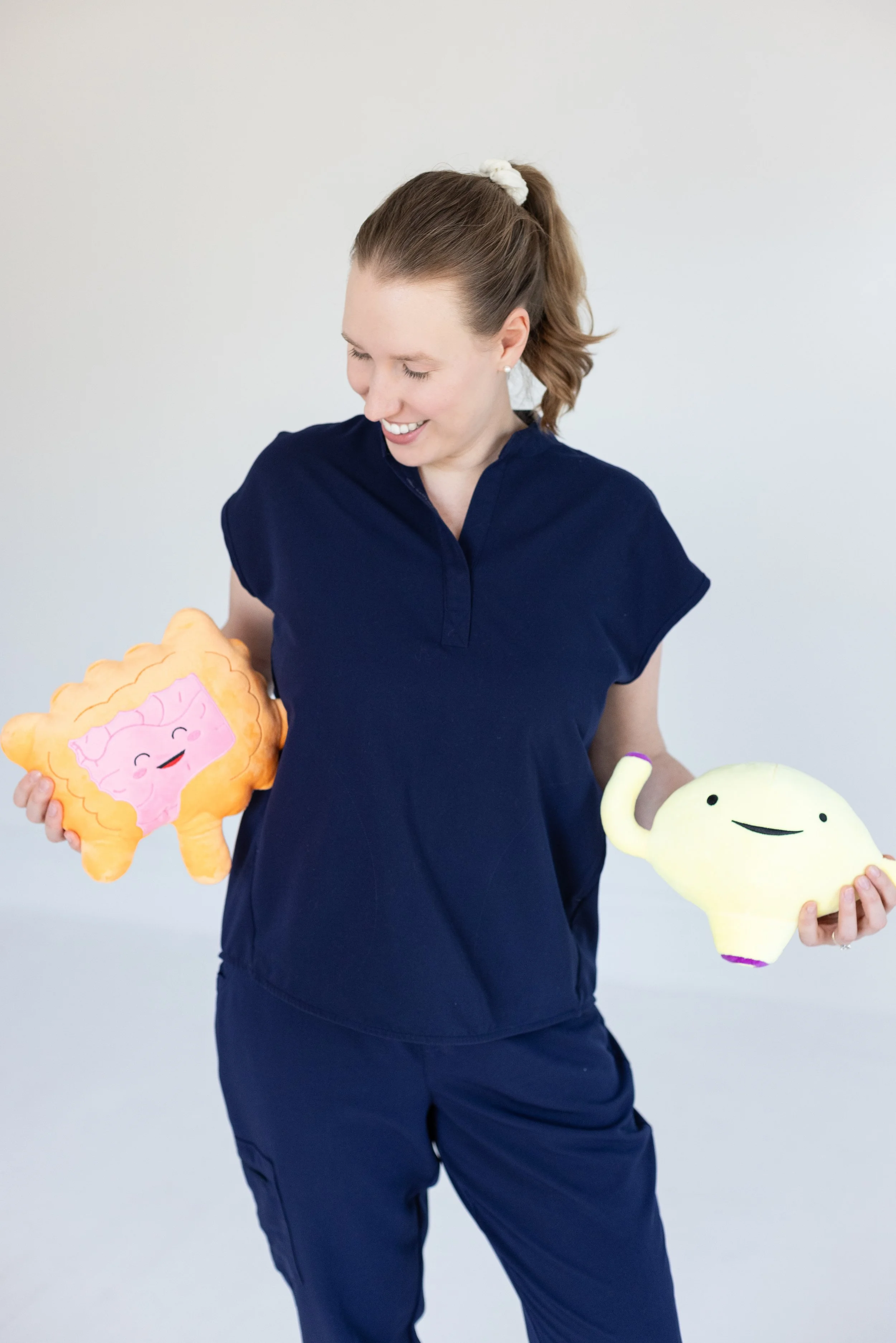 Dr. Savannah holds plush bowel and bladder toys that she uses for pediatric pelvic health therapy